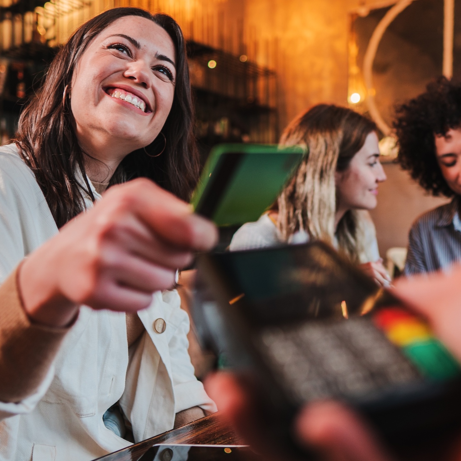 A young woman is paying for her bill with a credit card.