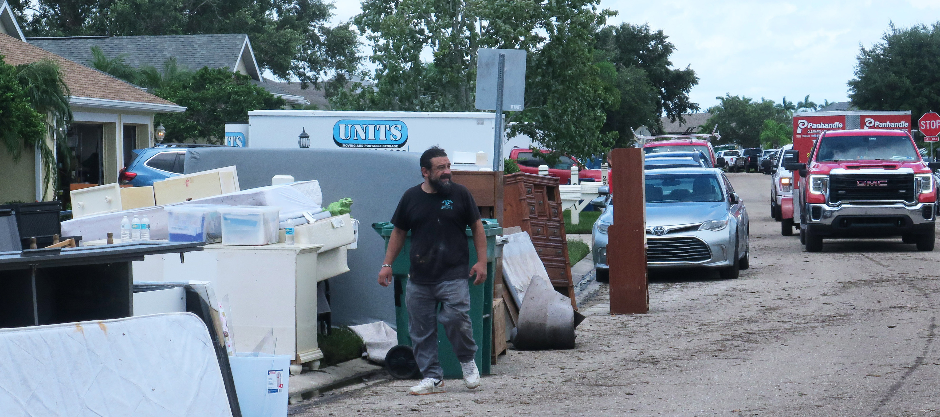 stands in front of a home in the Laurel Meadows neighborhood which was flooded by rains from Tropical Storm Debby.