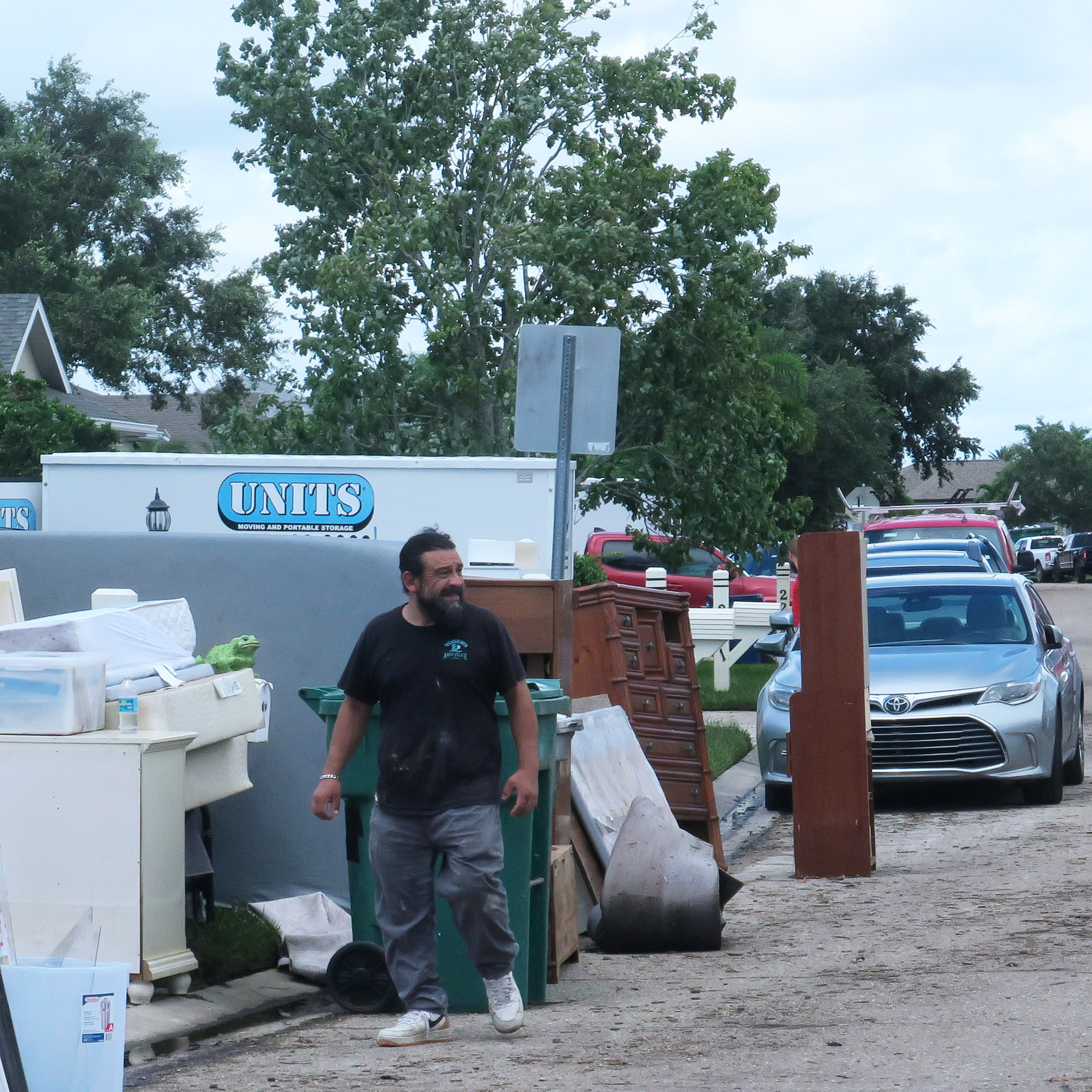 stands in front of a home in the Laurel Meadows neighborhood which was flooded by rains from Tropical Storm Debby.