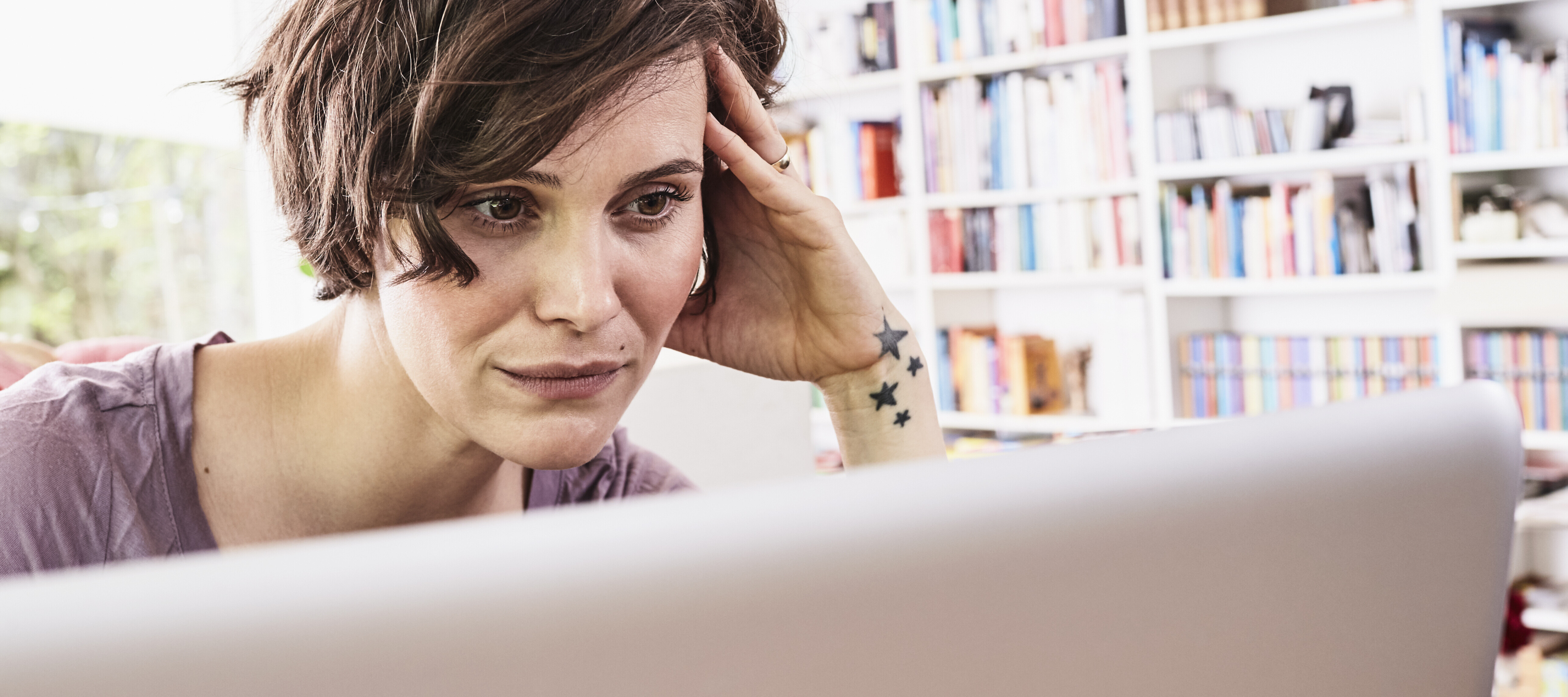 Frustrated woman looking at job applications on her computer.
