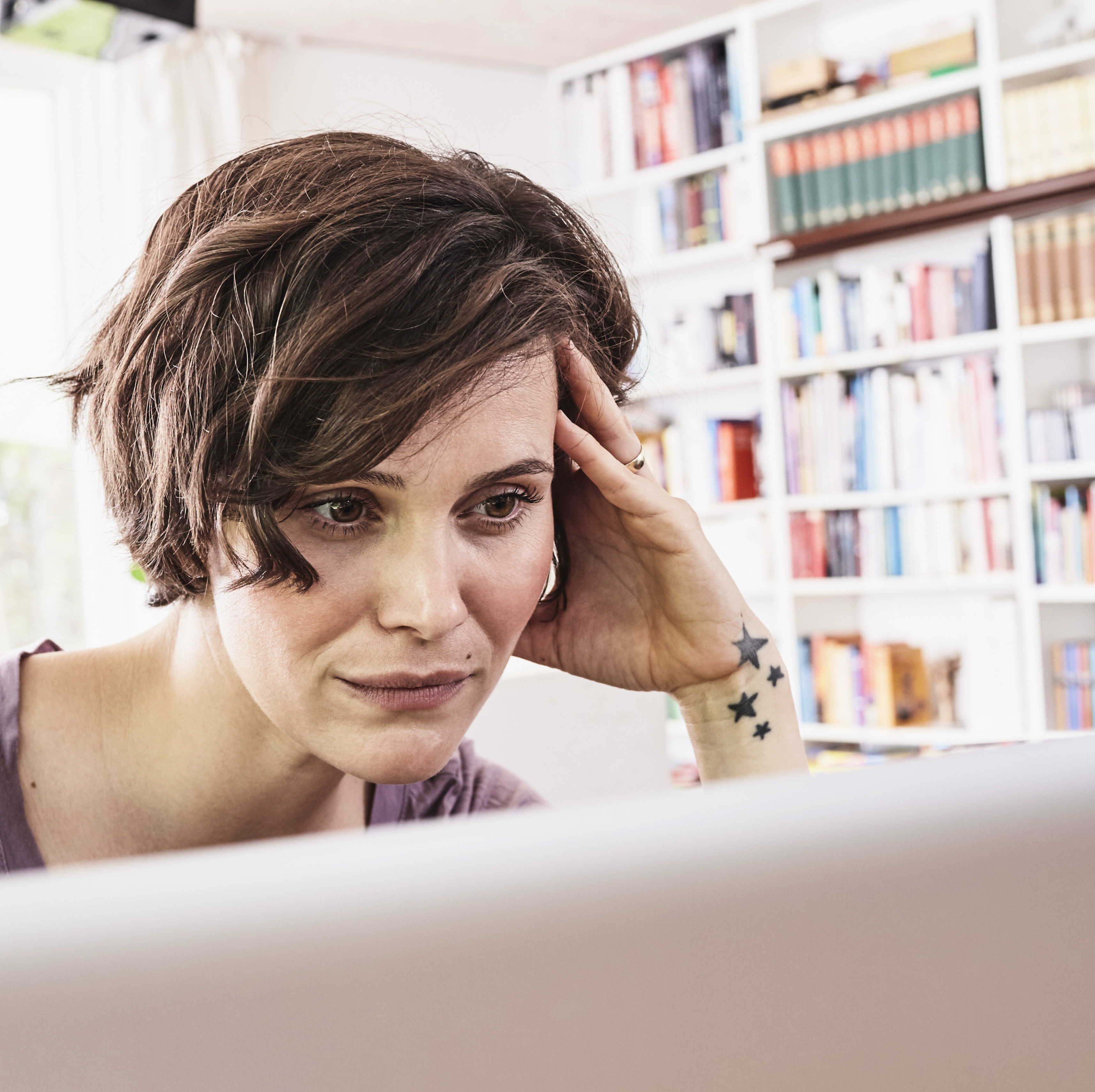 Frustrated woman looking at job applications on her computer.