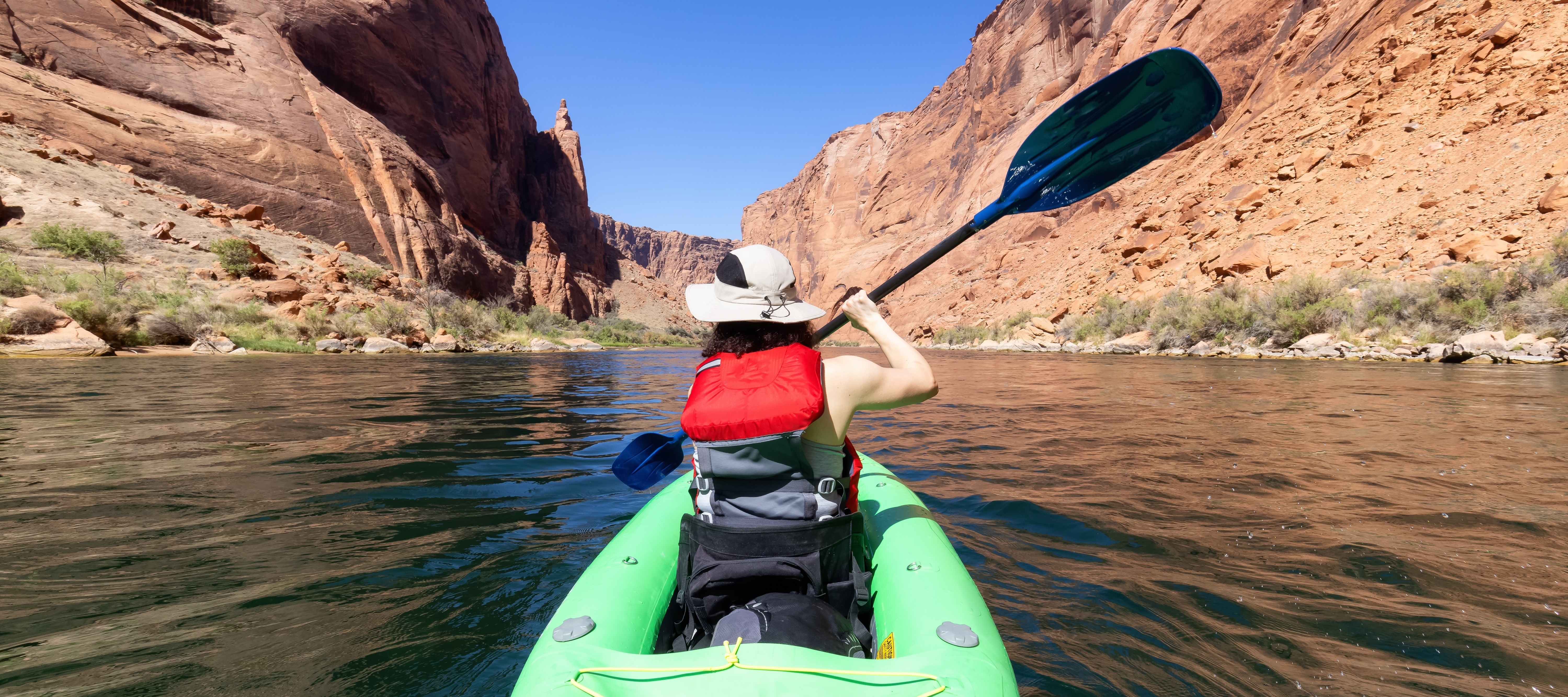 A woman in a Kayak paddling in Colorado River. Glen Canyon, is one of many U.S. parks users who could face higher visit fees in 2026.