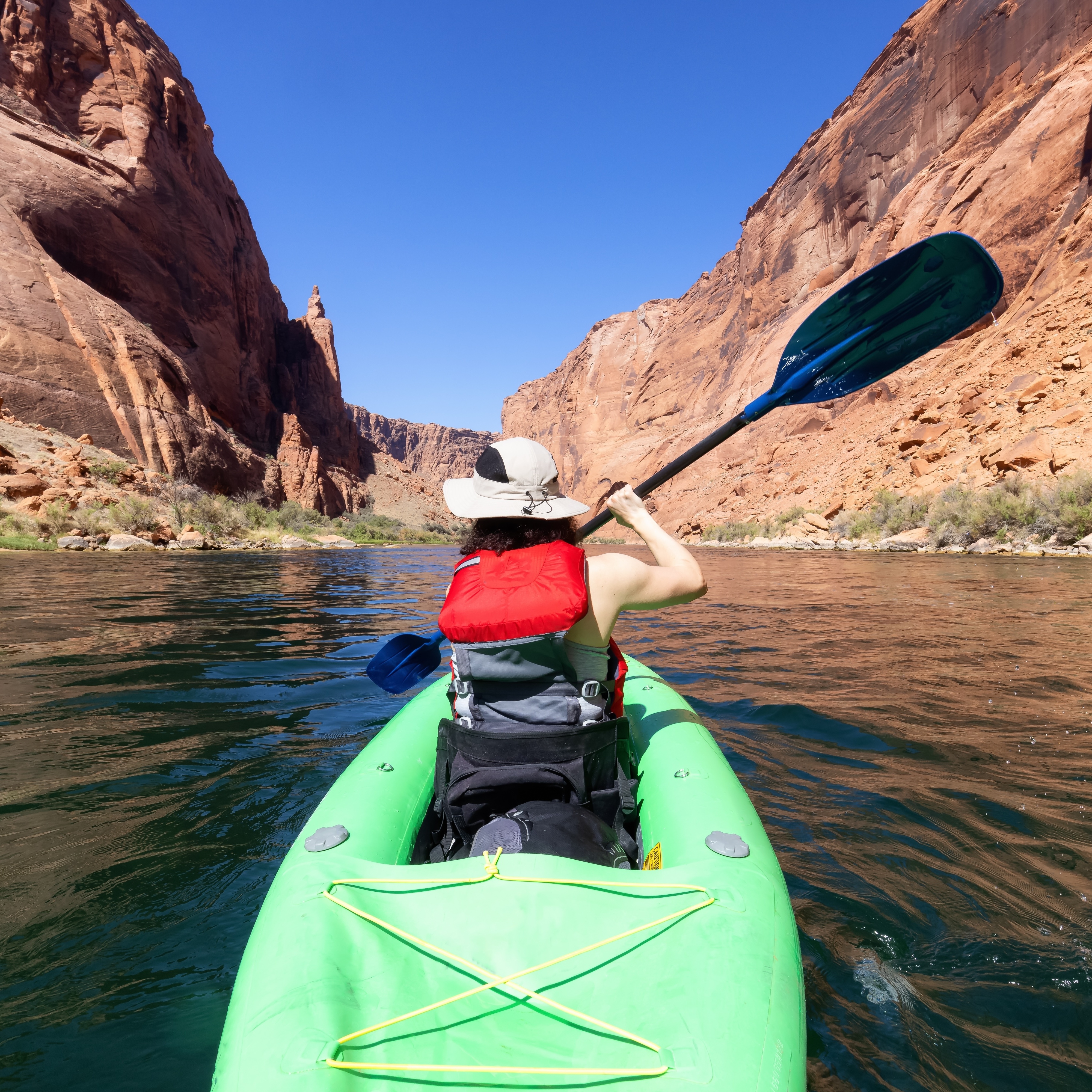 A woman in a Kayak paddling in Colorado River. Glen Canyon, is one of many U.S. parks users who could face higher visit fees in 2026.