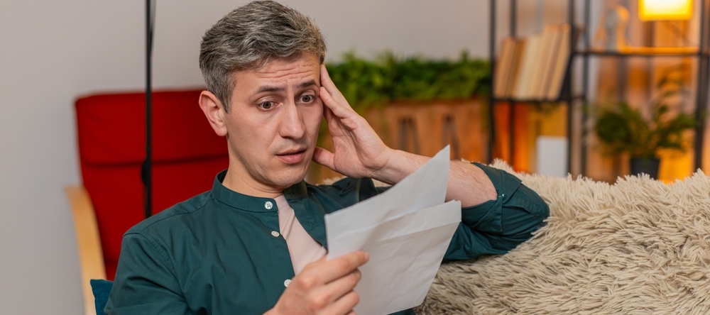 Man reading papers looking confused