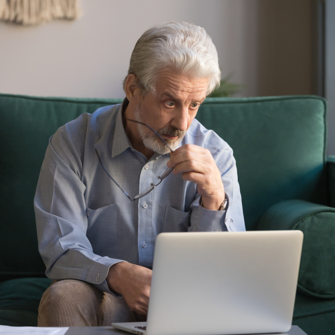 Grey-haired man on computer