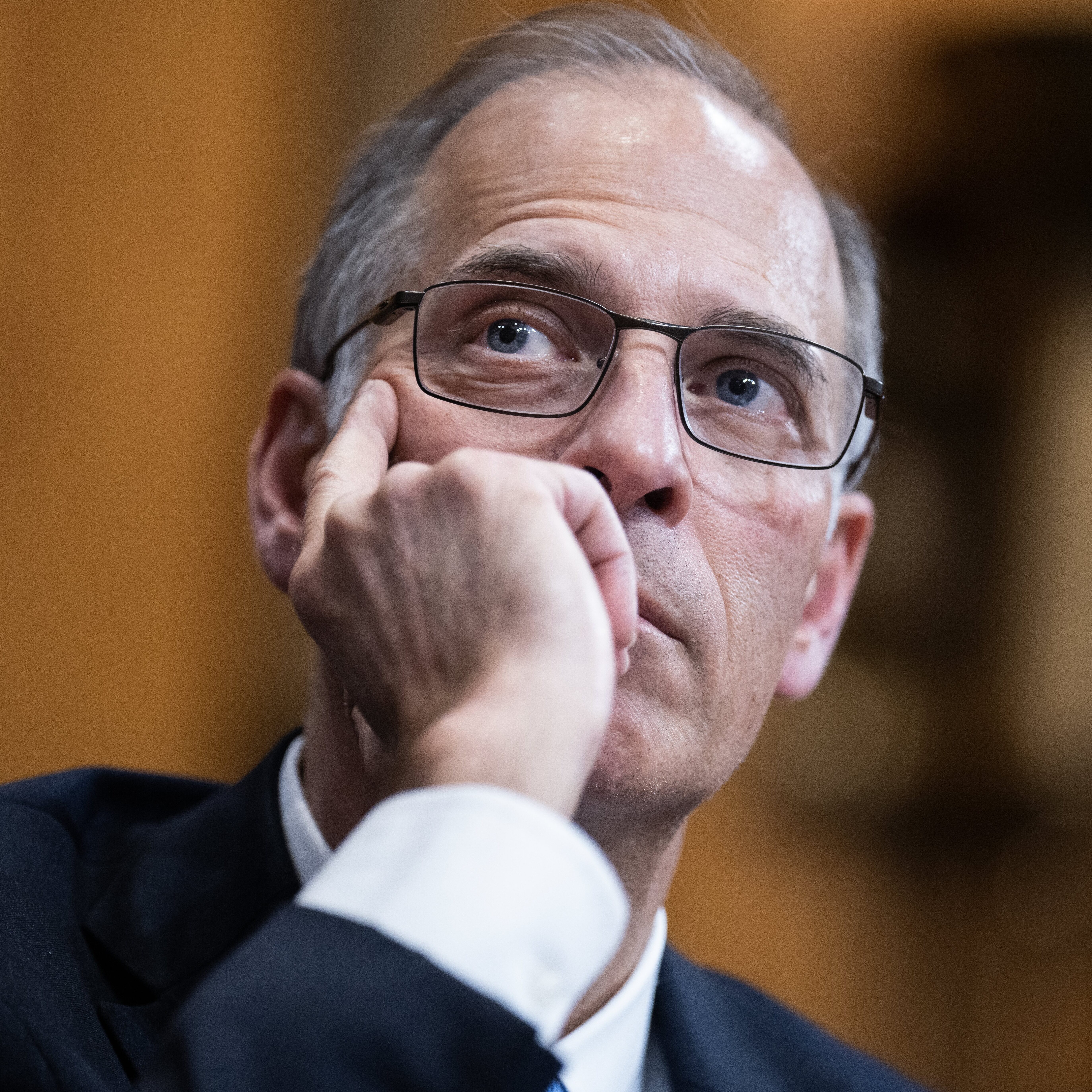 Moody's Economist Mark Zandi presses one hand into the side of his cheek, thinking deeply.