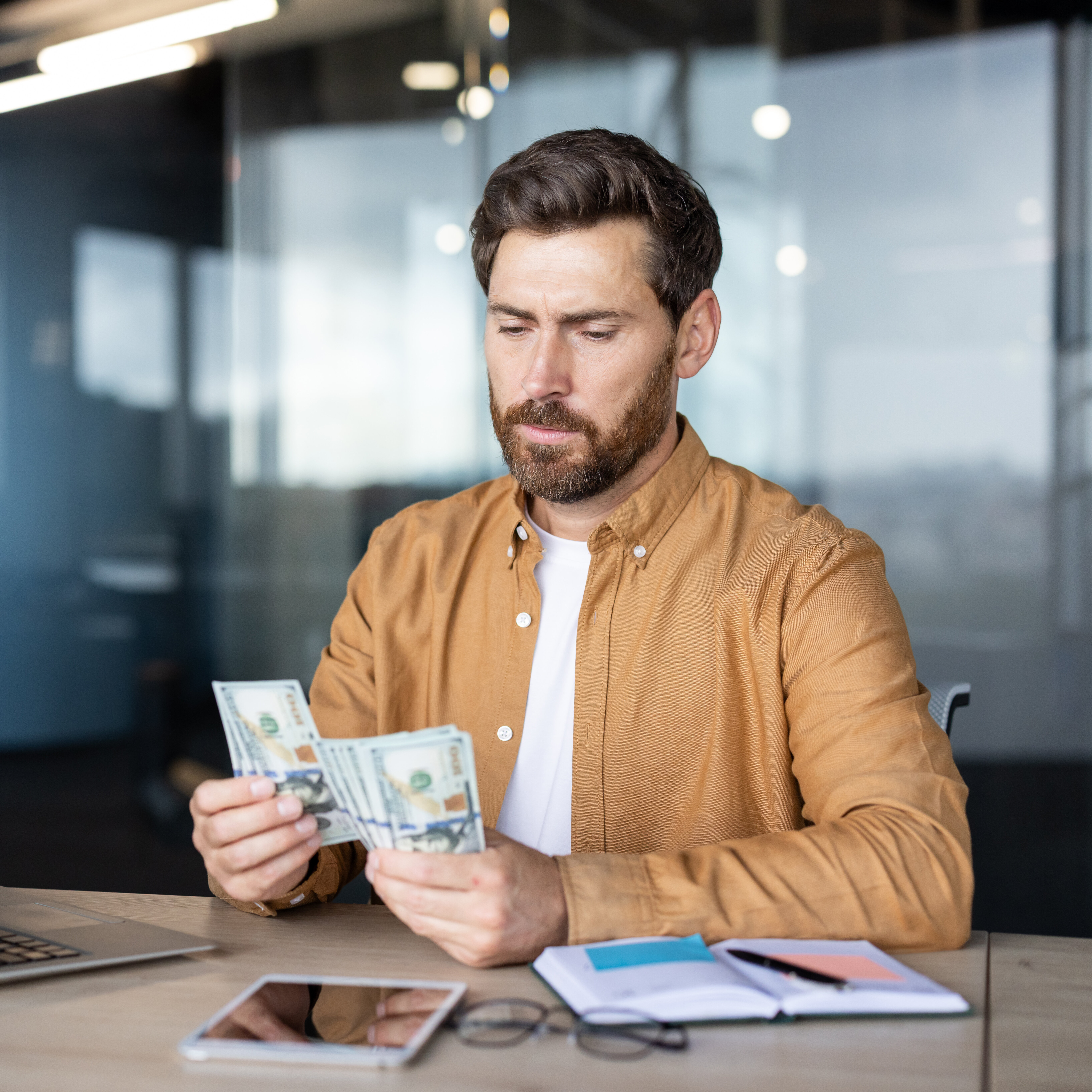 A man counts money at his deck.