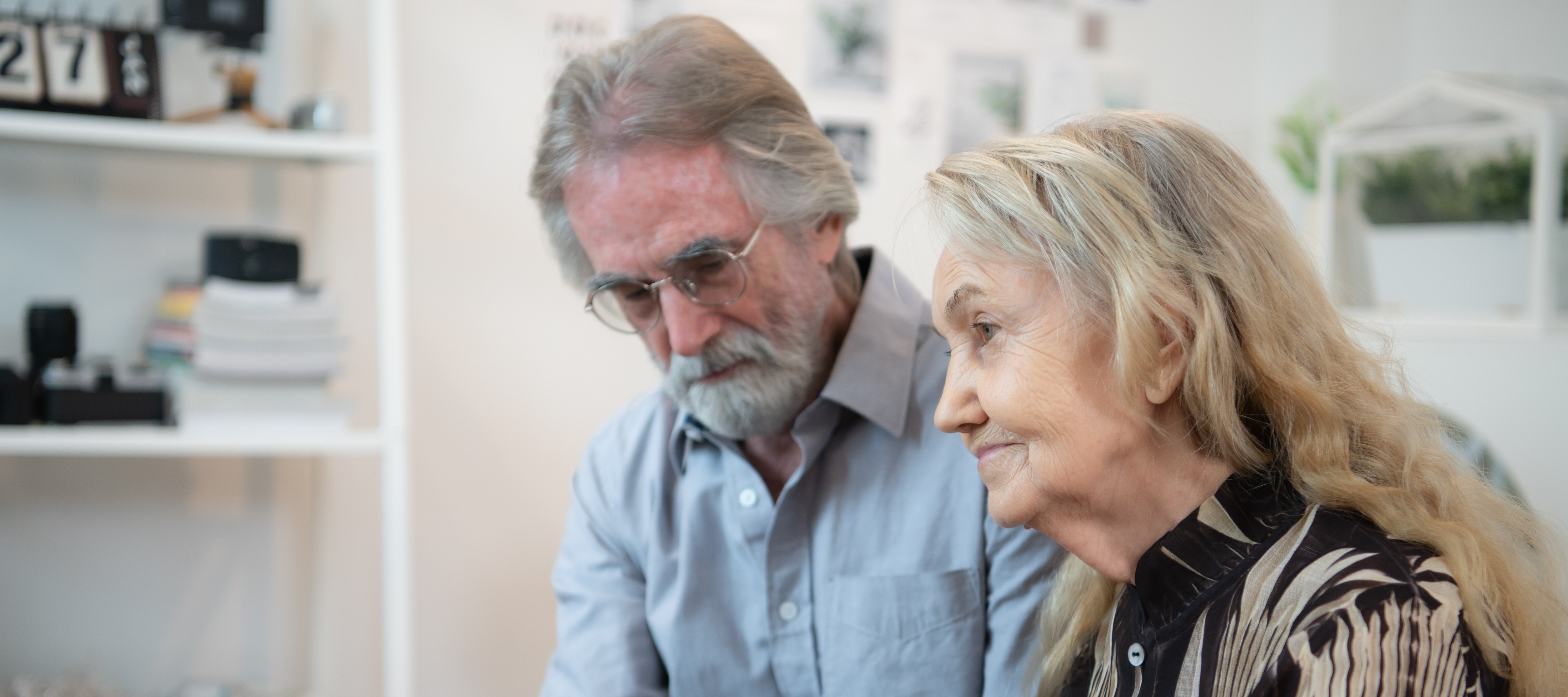 An older couple hold hands as they wait for a long term nursing care staffer to join them.