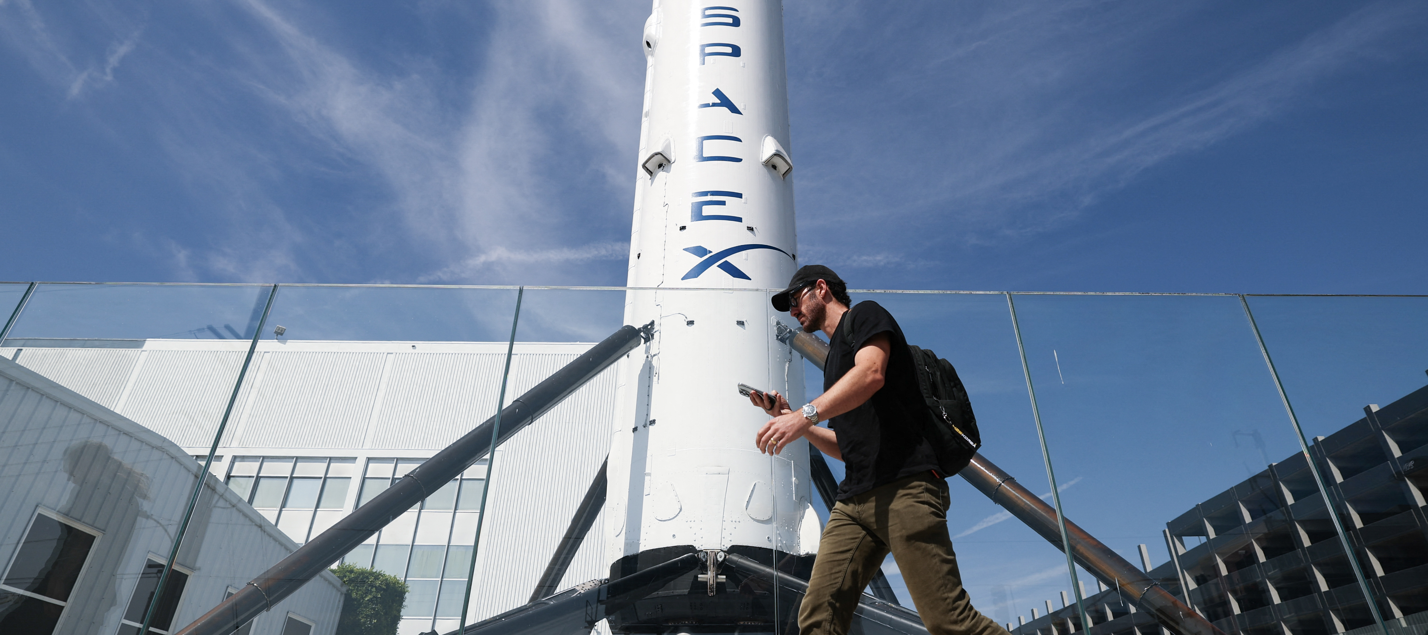 A man walks by a SpaceX Falcon 9 rocket.