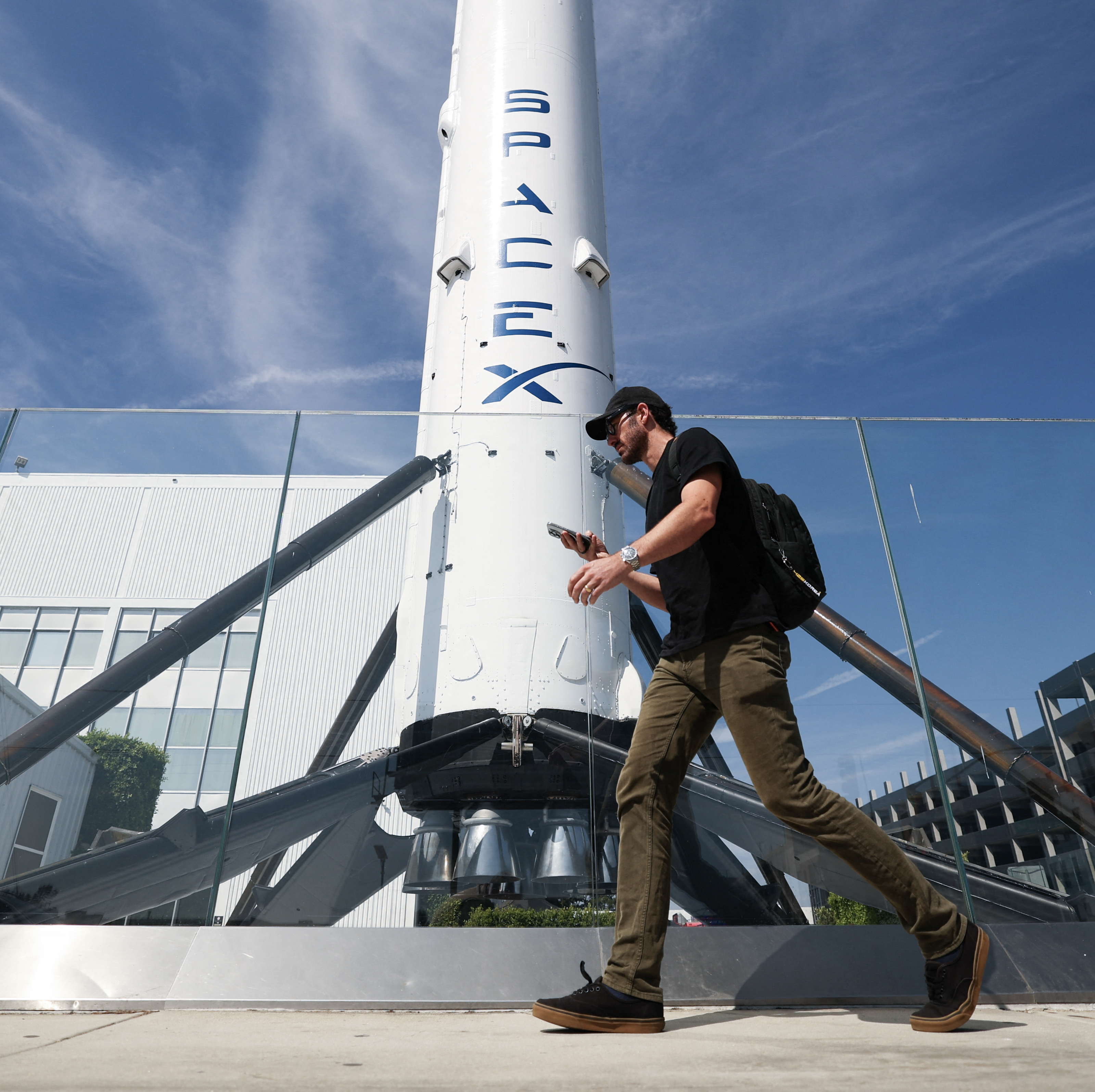 A man walks by a SpaceX Falcon 9 rocket.