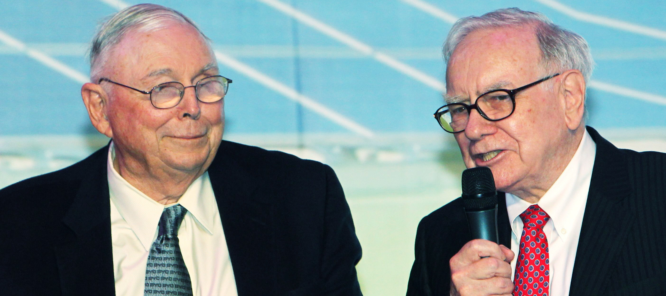 Charline Munger stands next to Warren Buffett on stage.