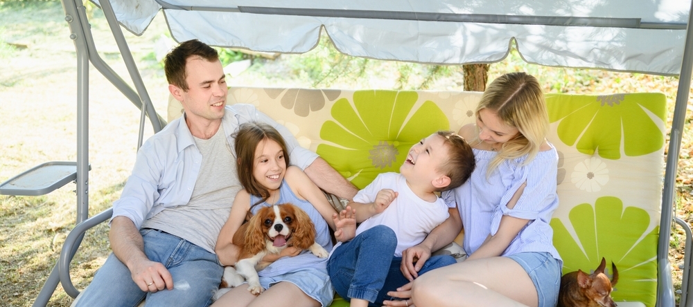 A happy family sits outside relaxing.