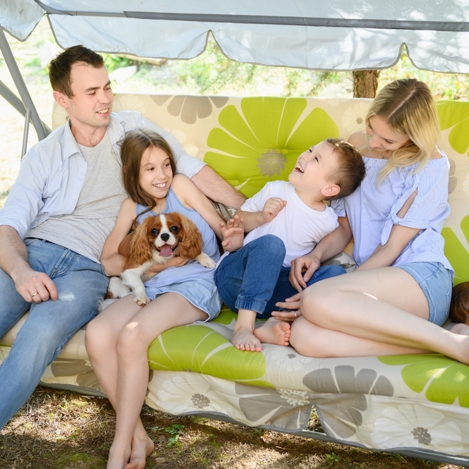 A happy family sits outside relaxing.