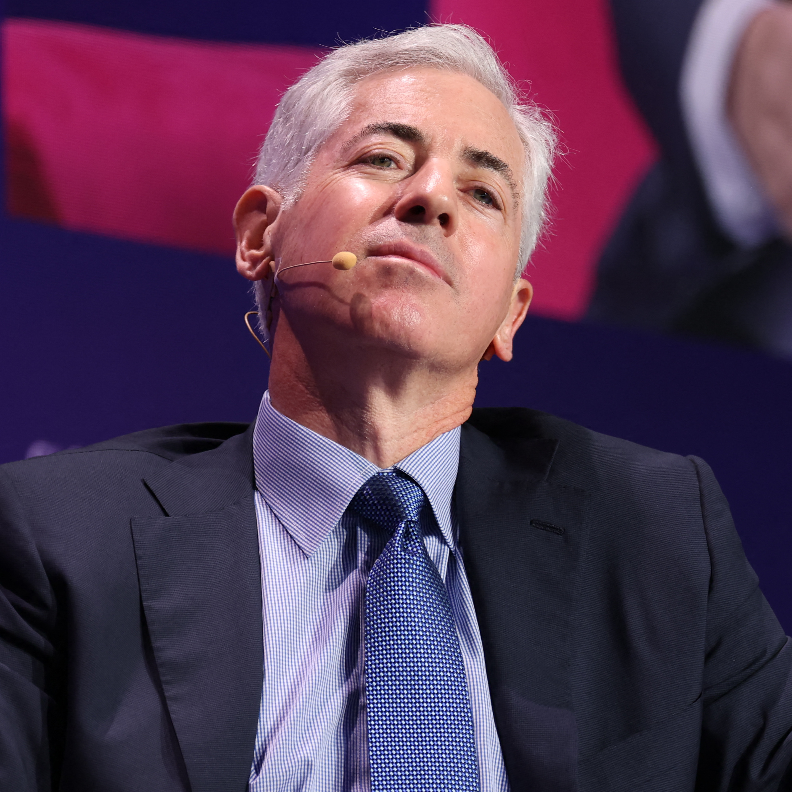Bill Ackman, Founder and CEO of Pershing Square Capital Management, leans backwards in his chair, looking down at the viewer.