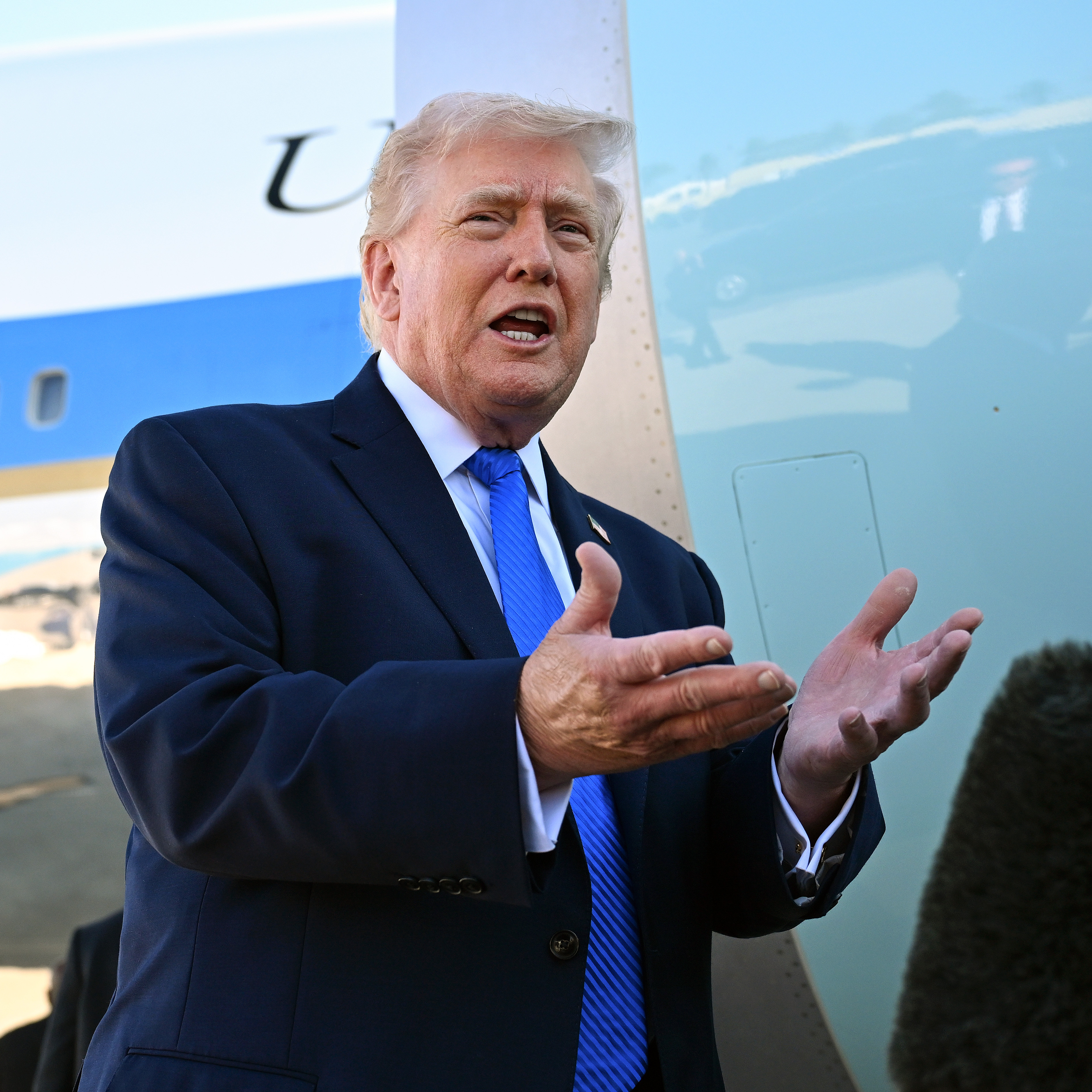 President Donald Trump speaks to reporters before boarding Air Force One at Palm Beach International Airport.