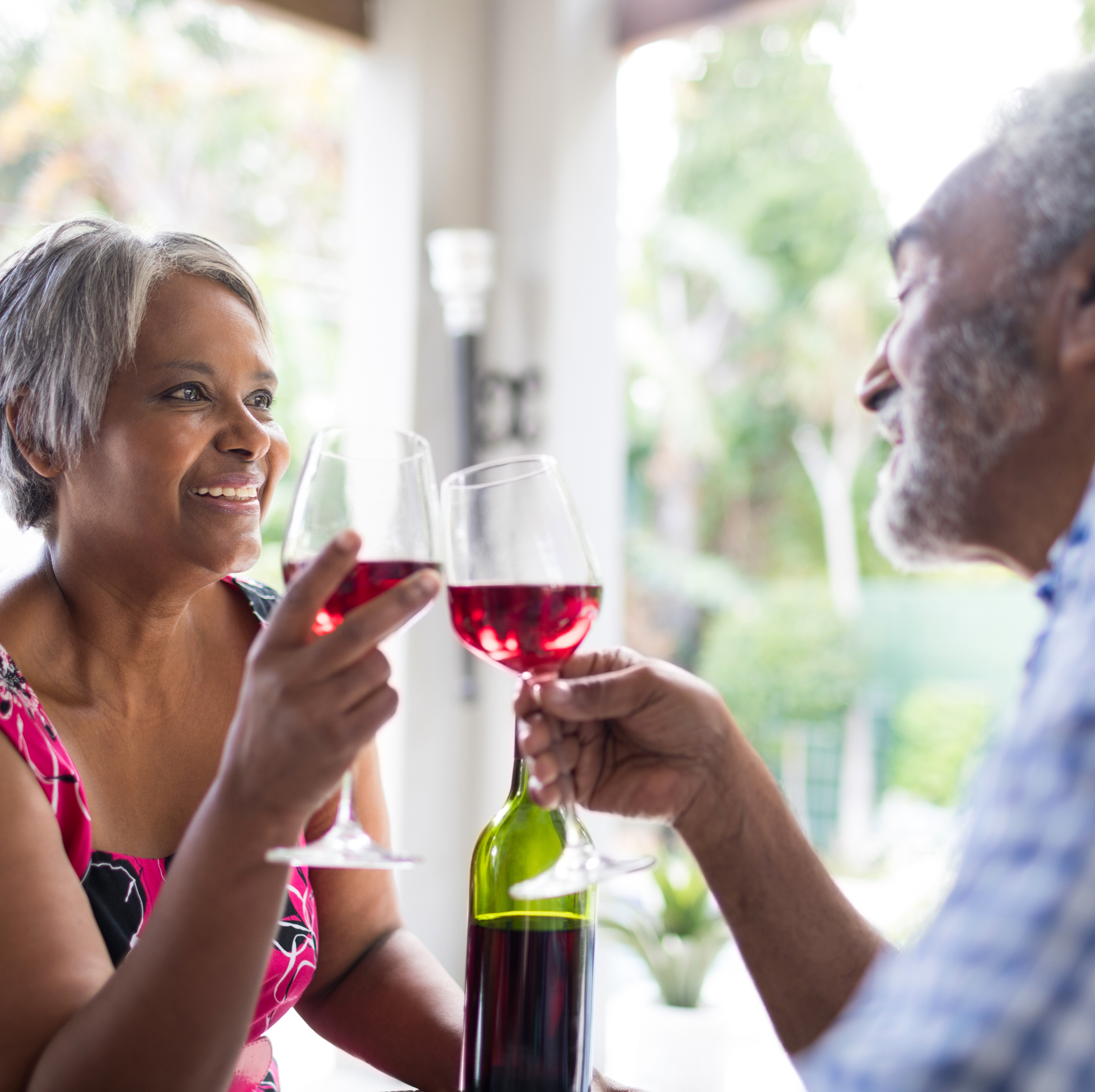 A retired couple enjoys a bottle of wine together.