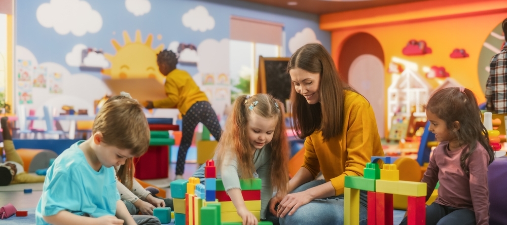 Young children play with colorful blocks in a classroom.