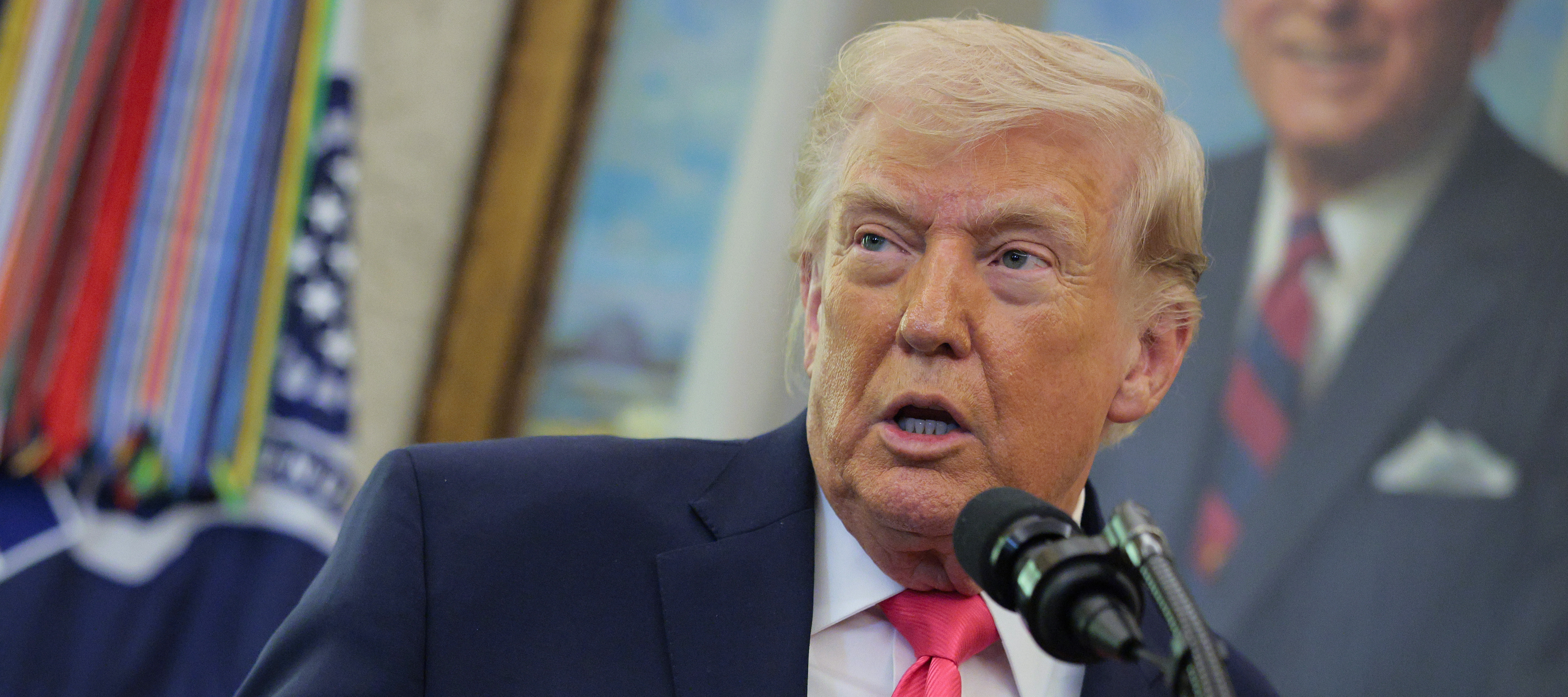 President Donald Trump speaks at a podium.