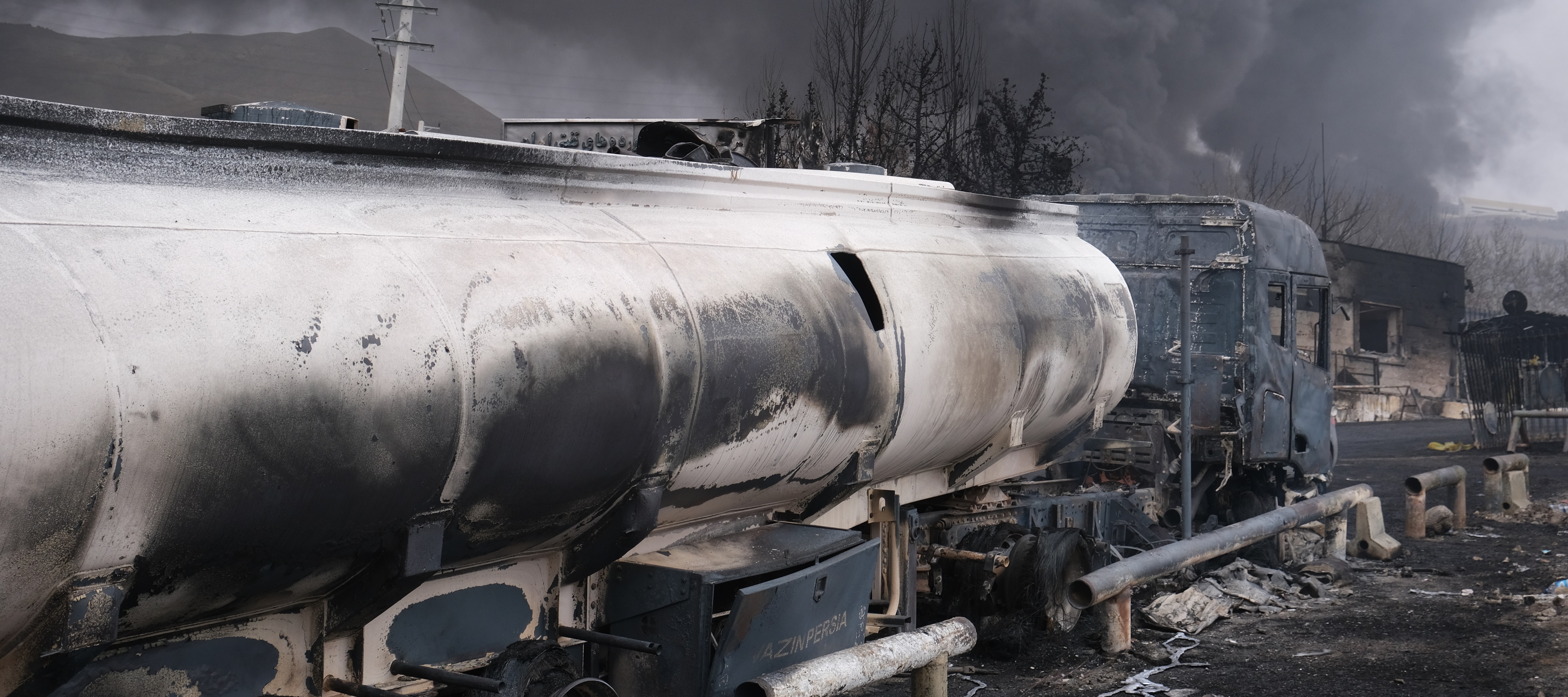 Plumes of smoke rise over the oil depot tanks hit by joint Israel-U.S. strikes.