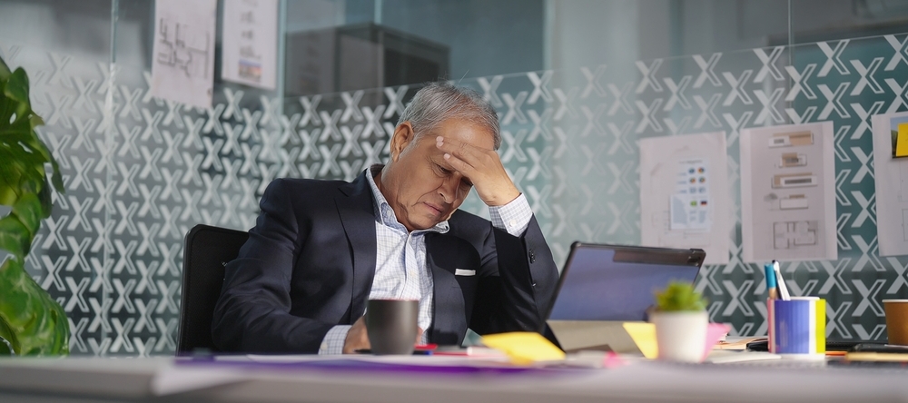 A frustrated older man looks at his computer.