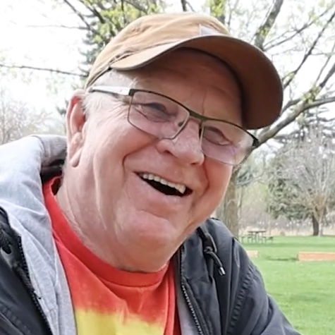 A close up of Dan Simpson smiling while talking about how his stop for a customer's Diet Coke resulted in over $70K of donations for his retirement.