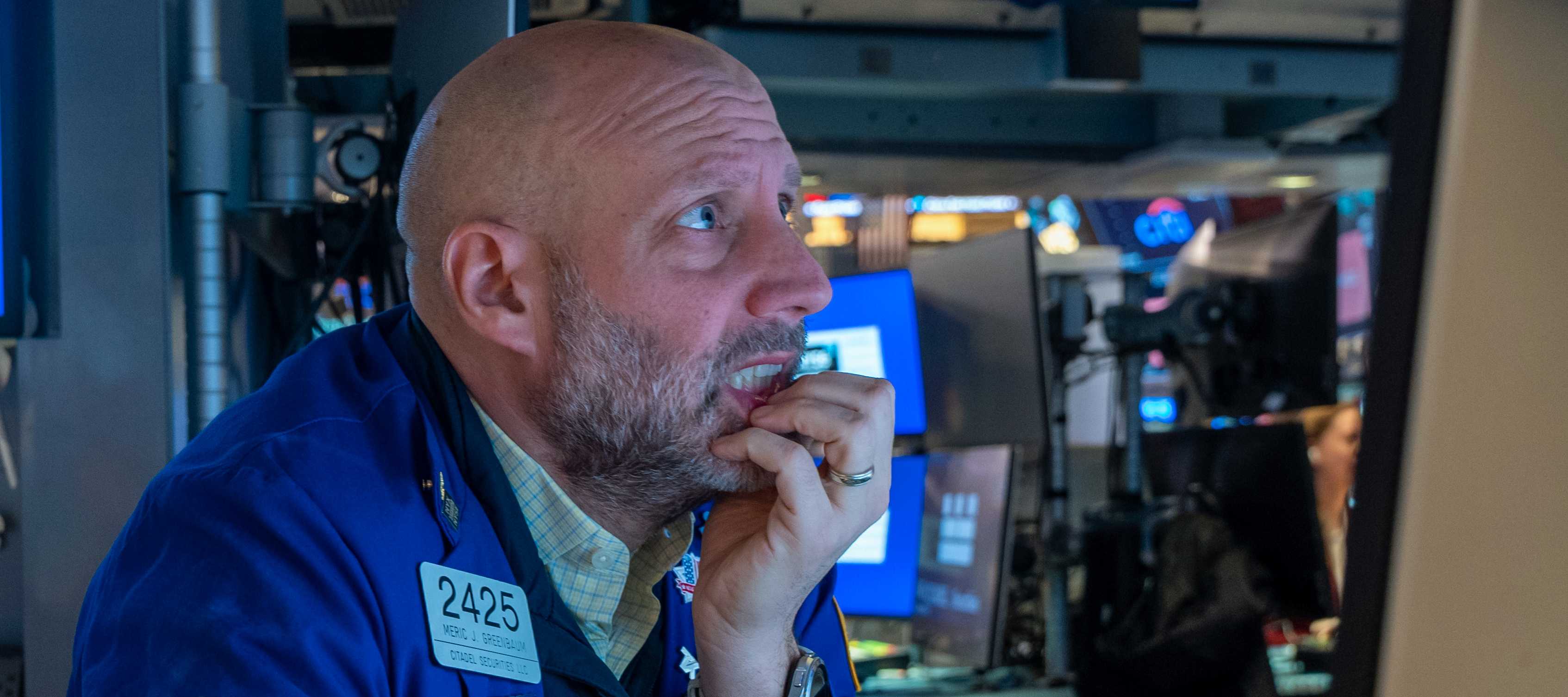 A trader at the New York Stock Exchange grimaces as he monitors global markets.