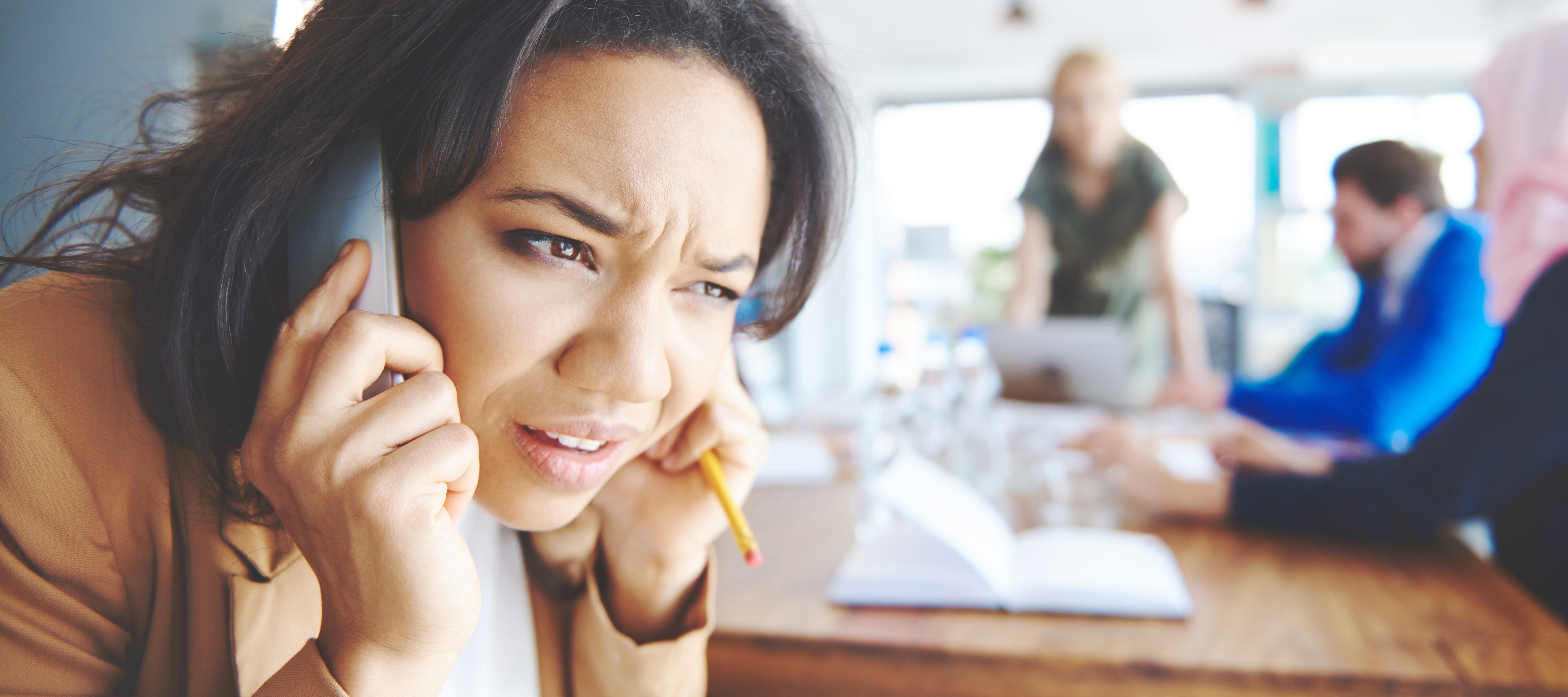 A woman, seen taking a call during a meeting, could be one of many Americans who complain of receiving robocalls as part of the "annoyance economy."