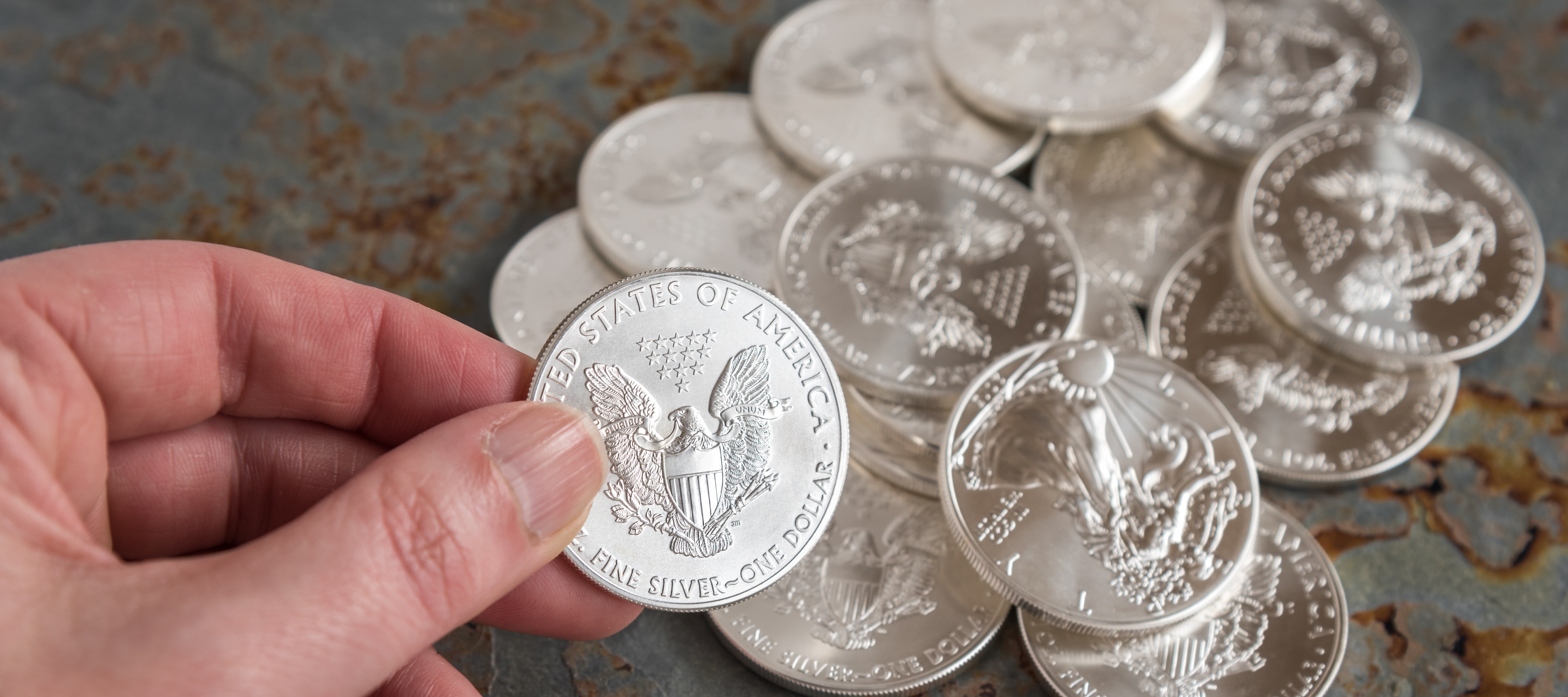 Person's hand holding a U.S. silver coin.