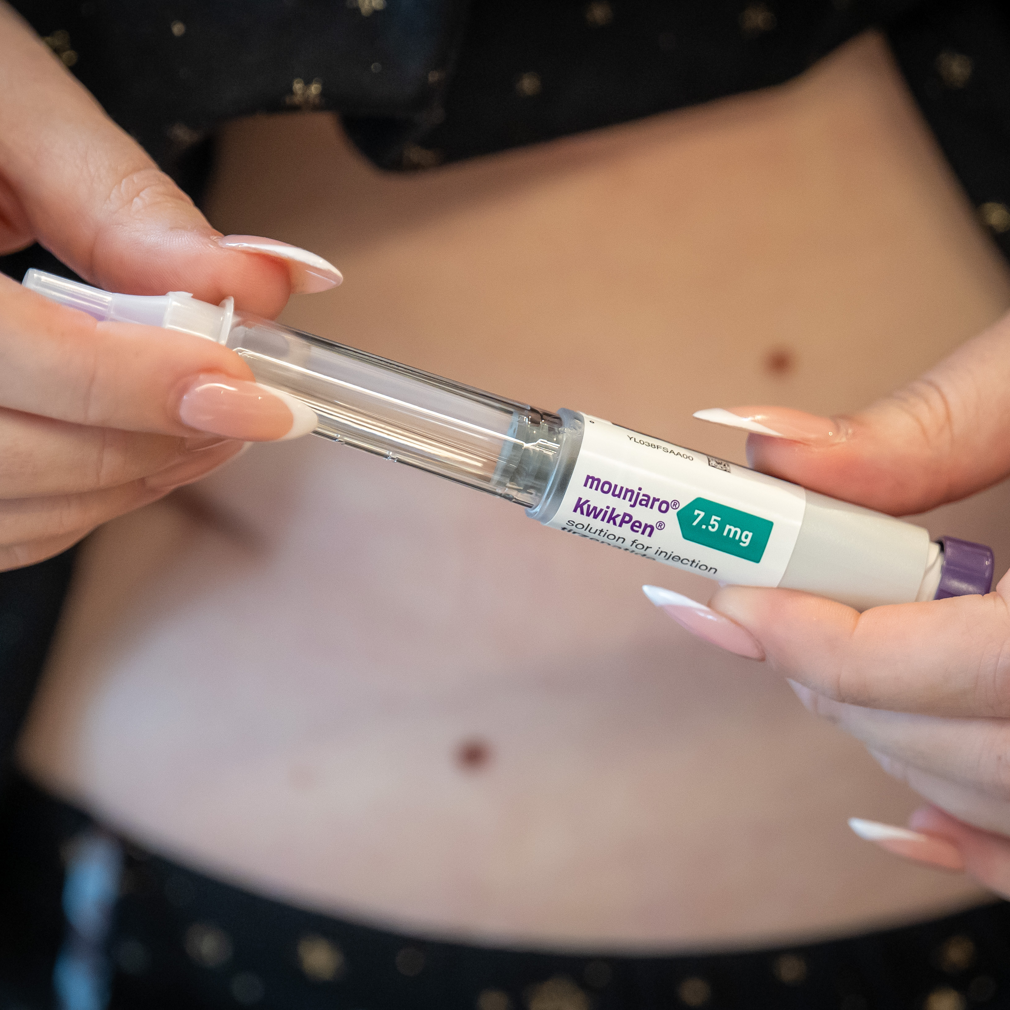 A close-up of a woman injecting a Mounjaro weight-loss jab