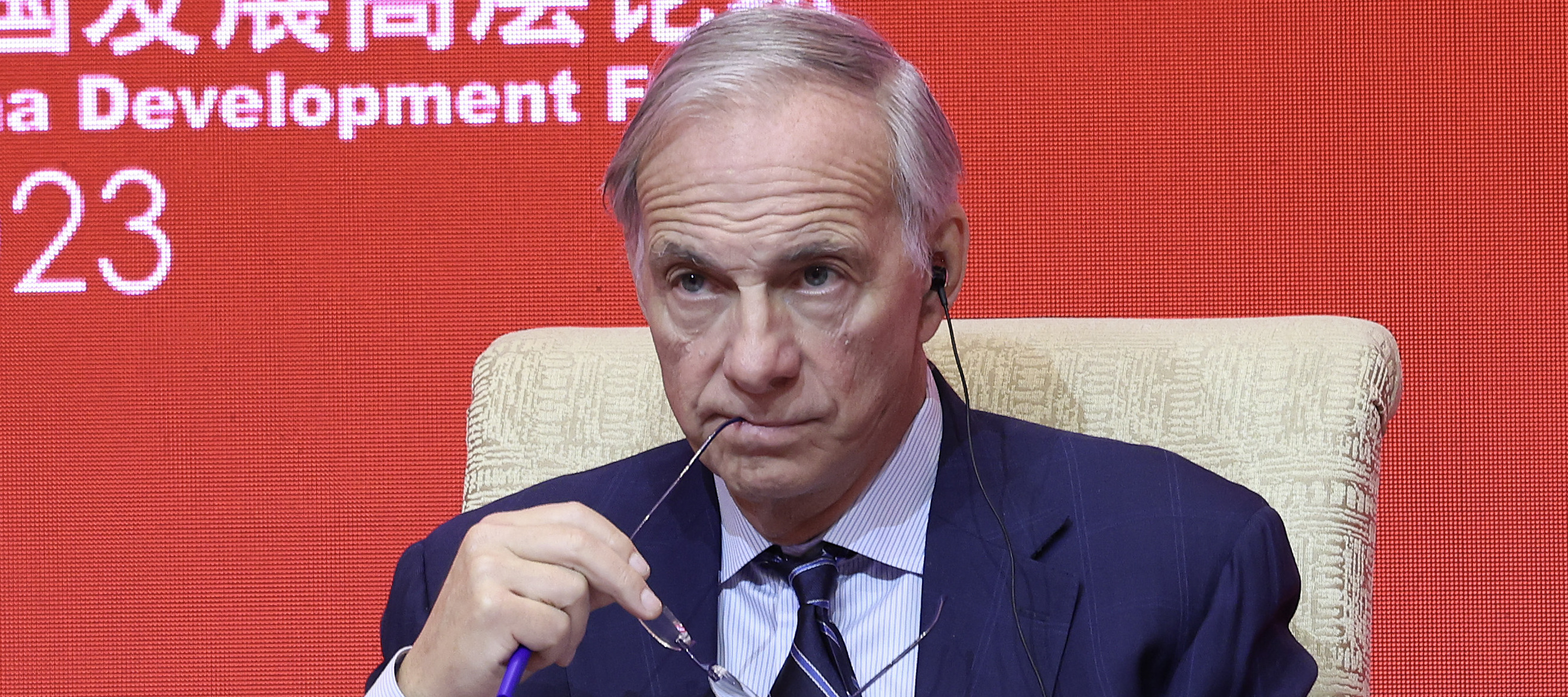 Ray Dalio, founder of Bridgewater Associates LP, looks on grimly backlit by a harsh, red LED screen.