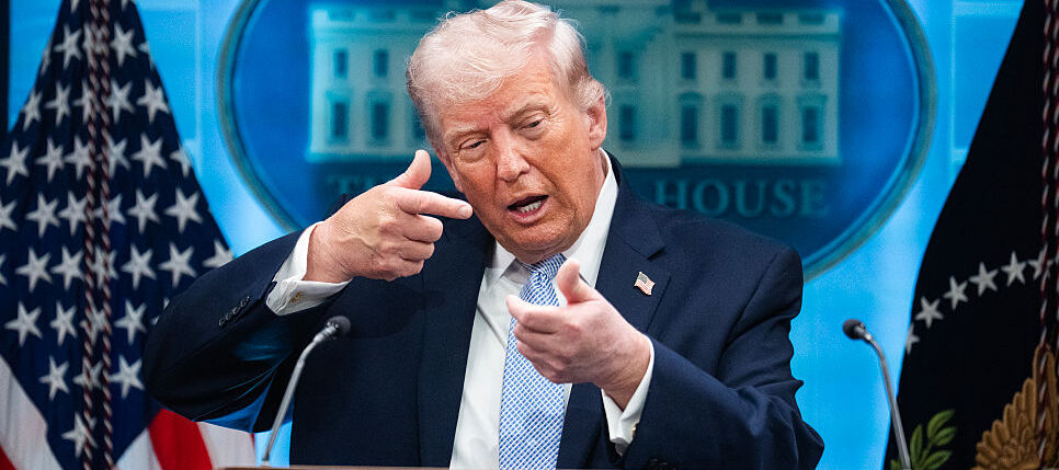 President Donald Trump mimics firing a gun during a White House news conference about the war on Iran.