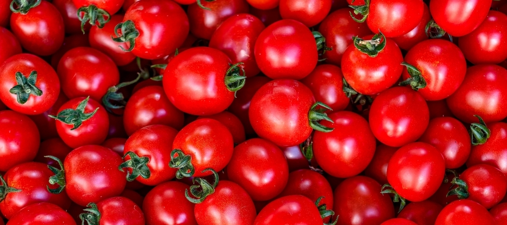 Fresh cherry tomatoes piled together in vibrant red.
