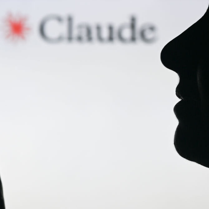 A photo of a person holding a phone in front of a Claude AI display