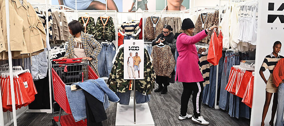 Three female shoppers look at clothing items in Target