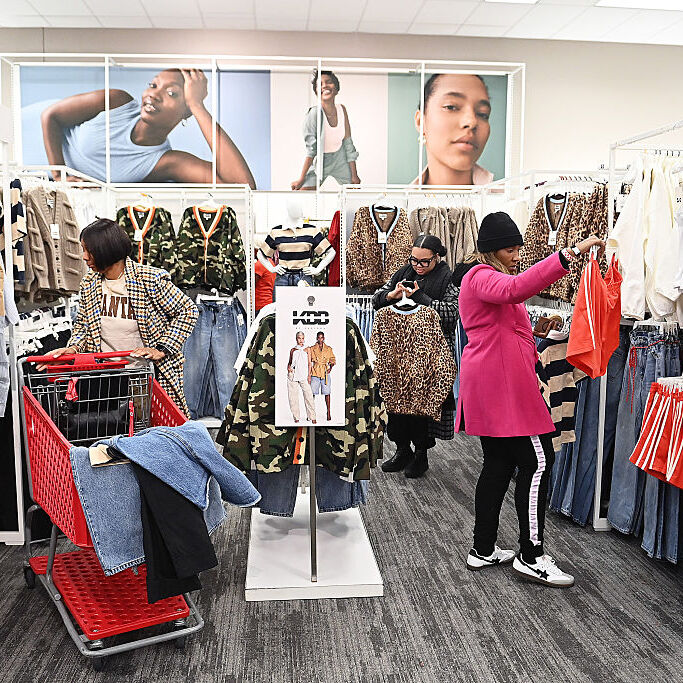 Three female shoppers look at clothing items in Target
