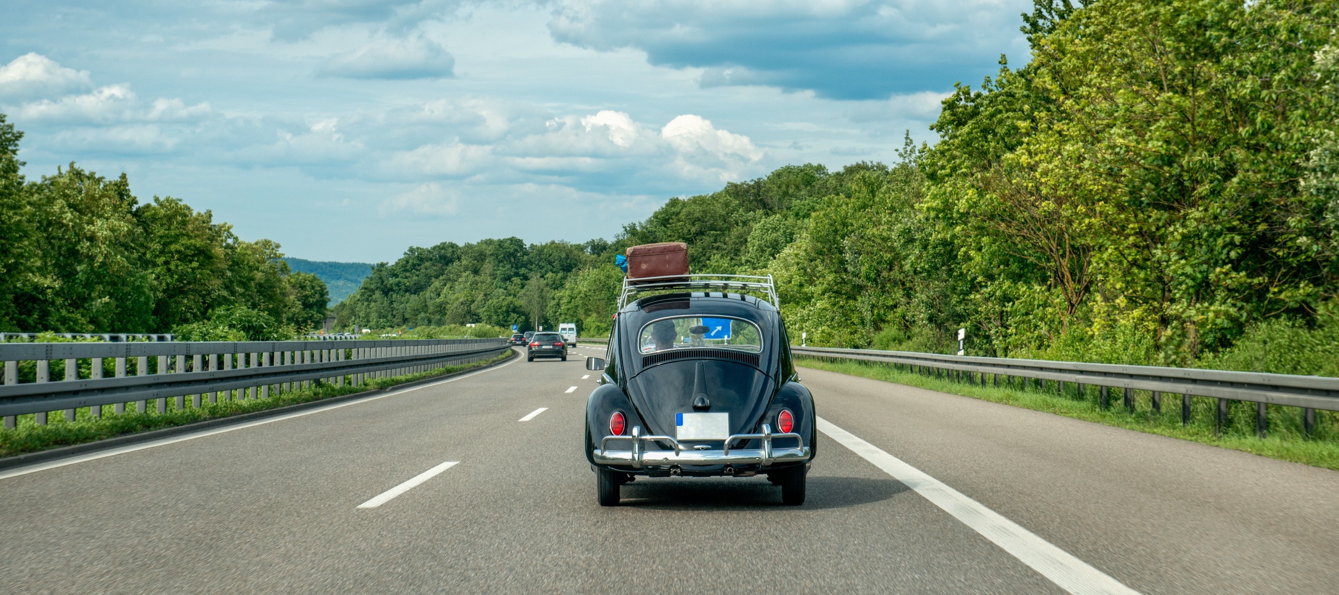 A VW bug driving down a highway