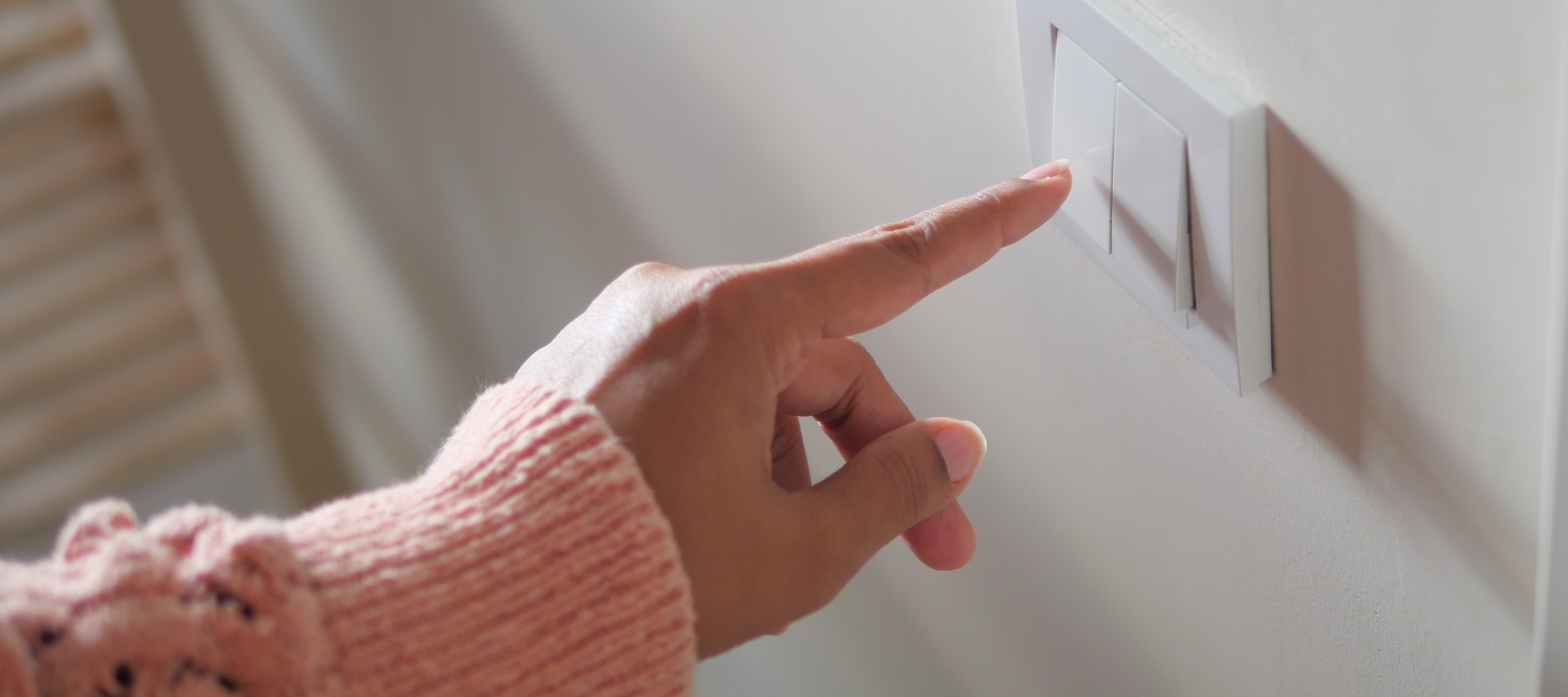 Close-up of woman's hand turning on light switch