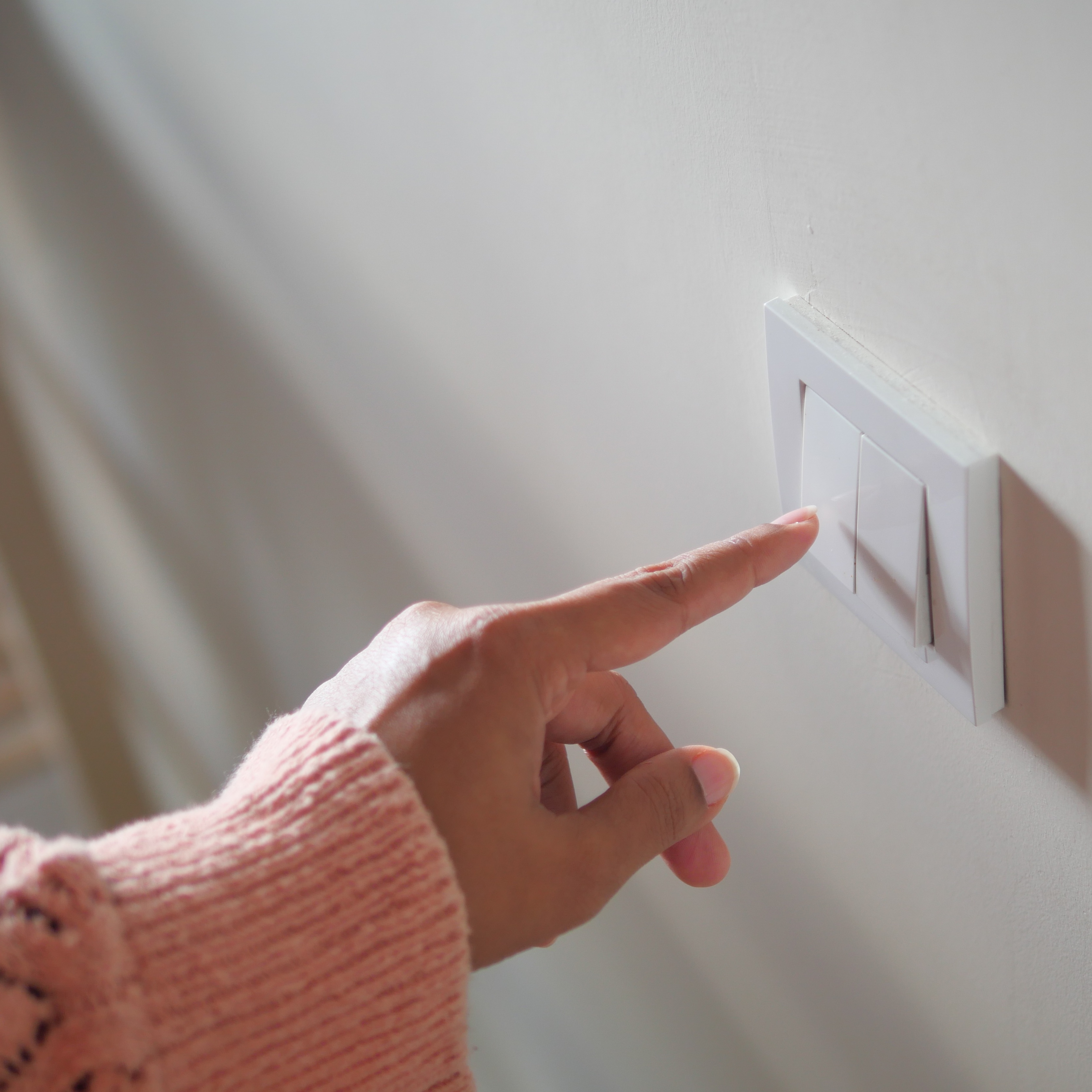 Close-up of woman's hand turning on light switch