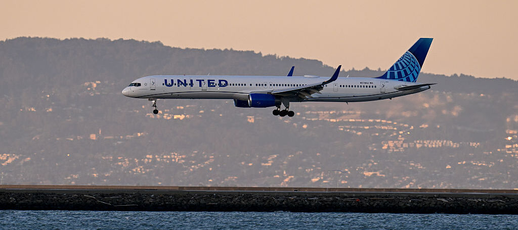 United Airlines plane flying over a body of water