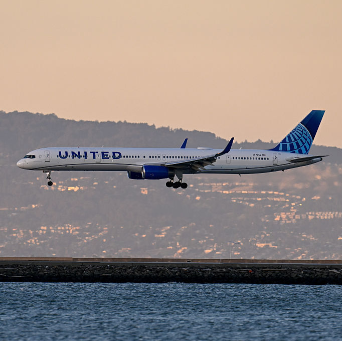 United Airlines plane flying over a body of water