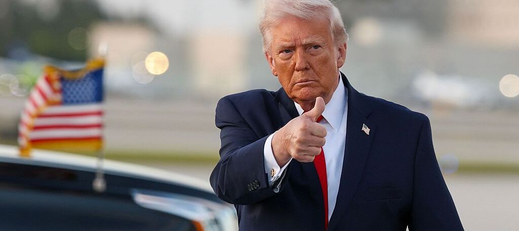 U.S. President Donald Trump waves to the media after walking off of Air Force One at Miami International Airport.