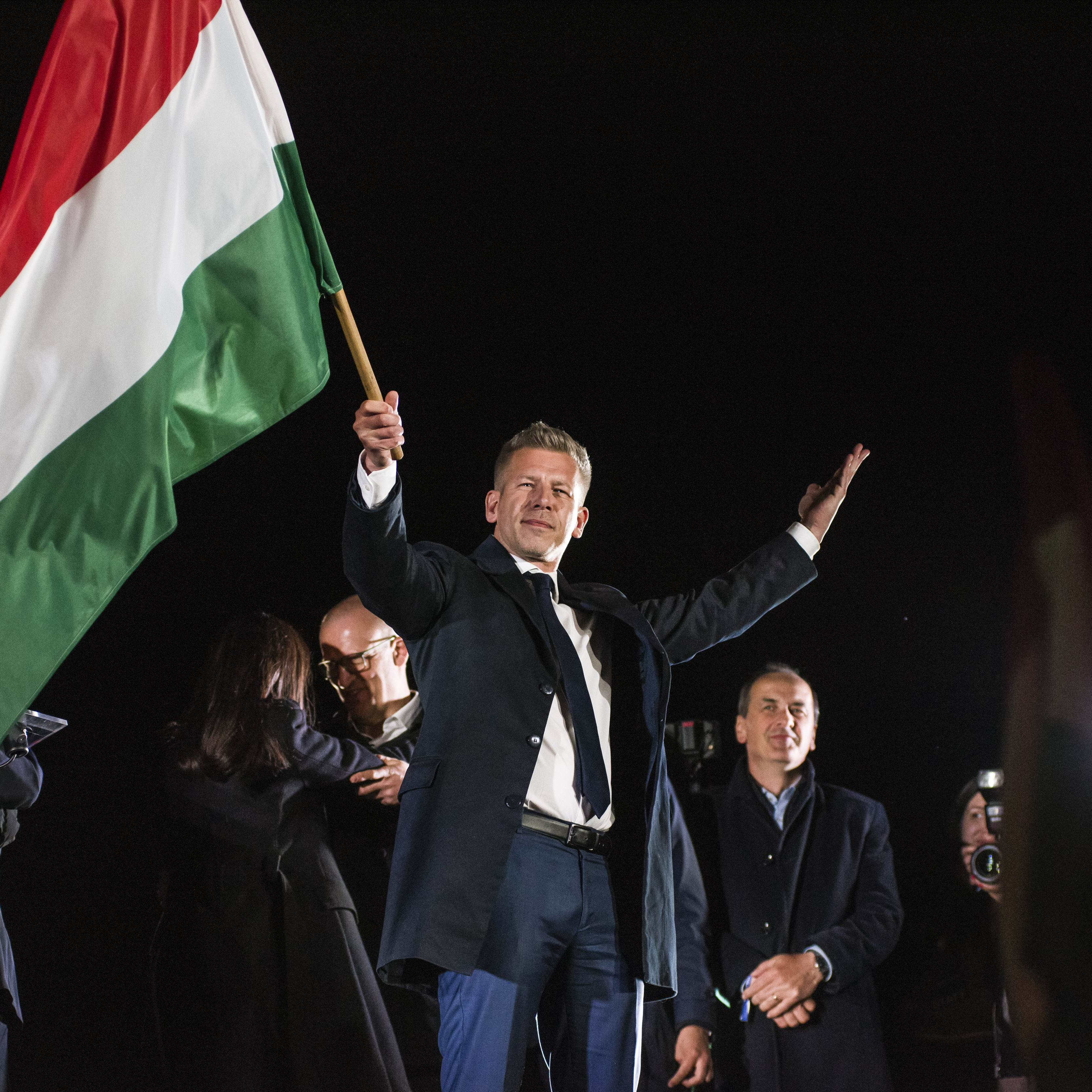 Peter Magyar waves the Hungarian flag after his speech during the Hungarian Civic Alliance