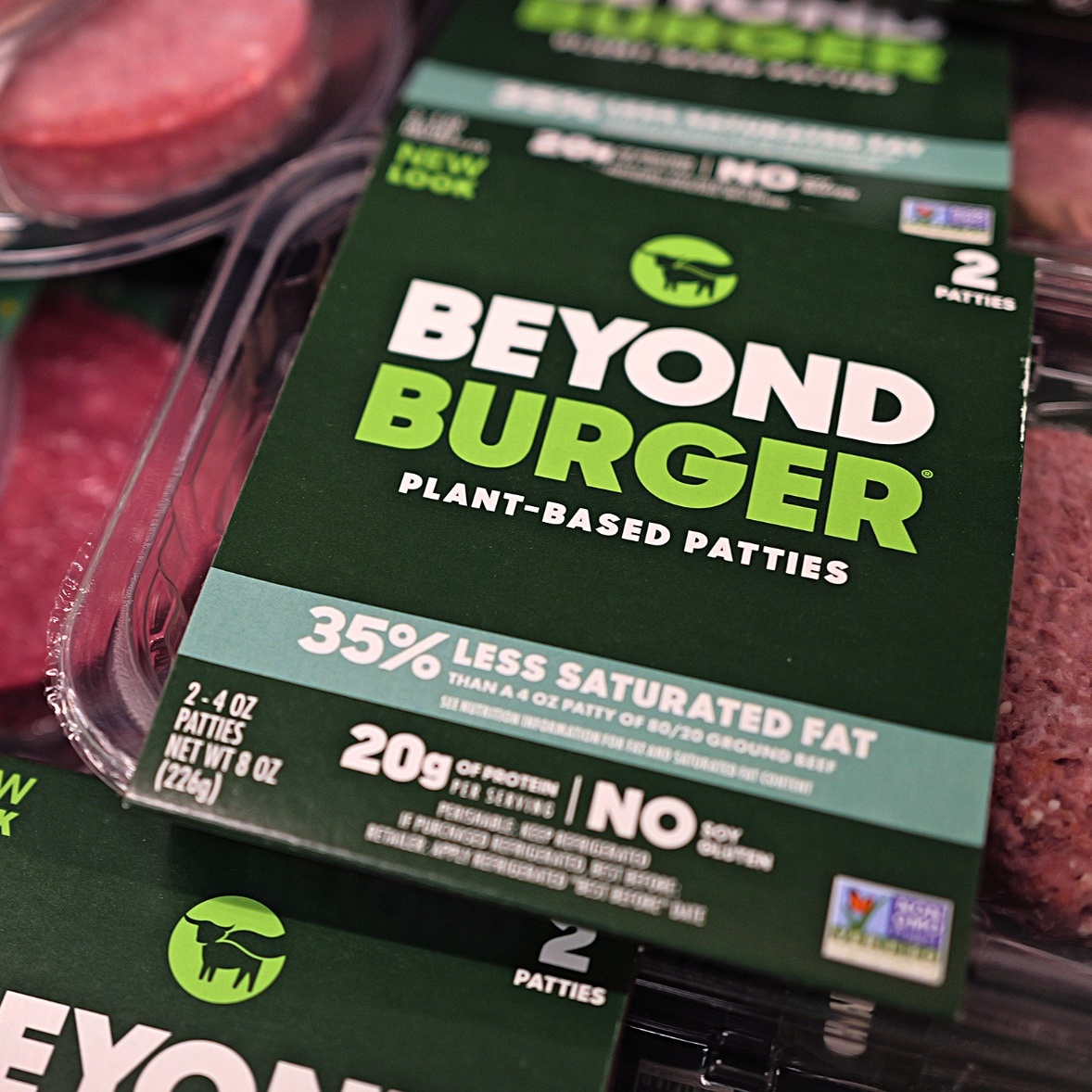 On the left, Ethan Brown speaks at podium, on the right a close up of beyond burger patties