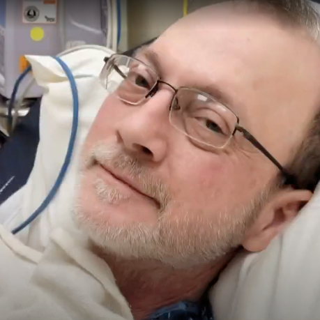 Eric Tennant, seen here in hospital before his death, had been a candidate for a relatively new treatment that was denied four times by his insurer.