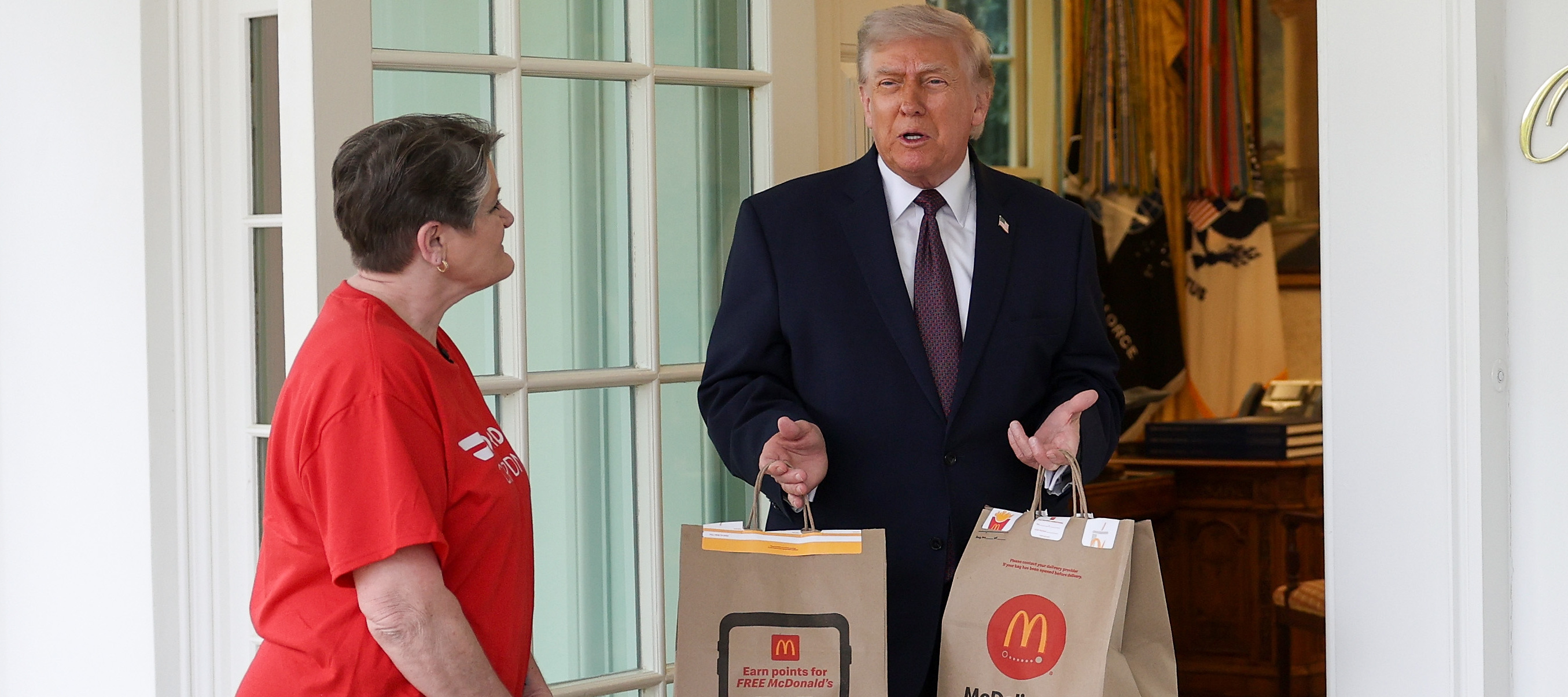 President Donald Trump receives a DoorDash delivery of McDonald's at the Oval Office of the White House.