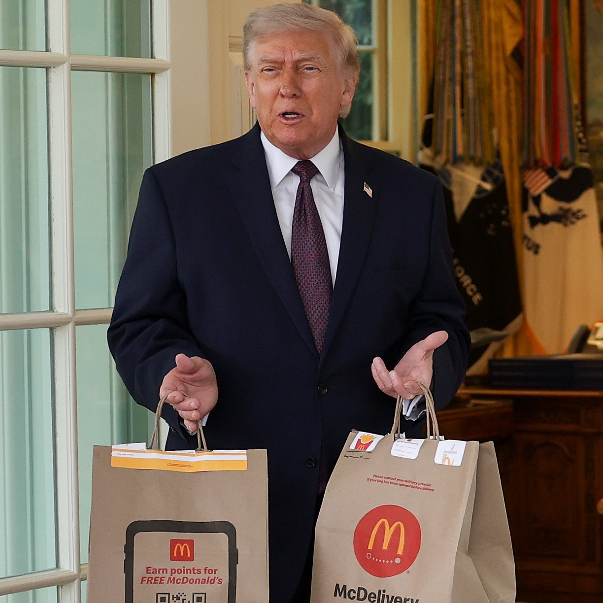 President Donald Trump receives a DoorDash delivery of McDonald's at the Oval Office of the White House.