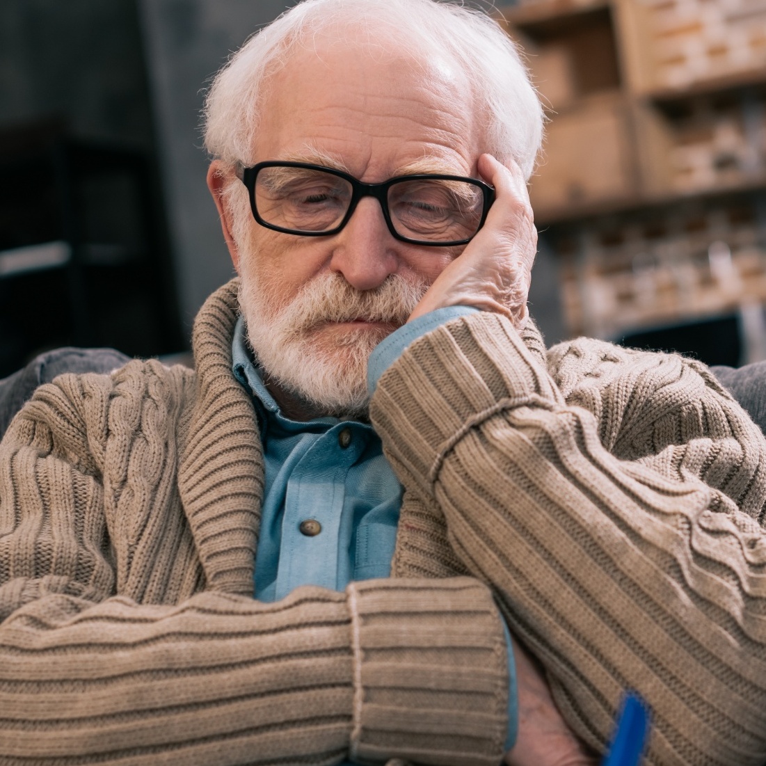 A senior man is worried as he sits with a nurse.