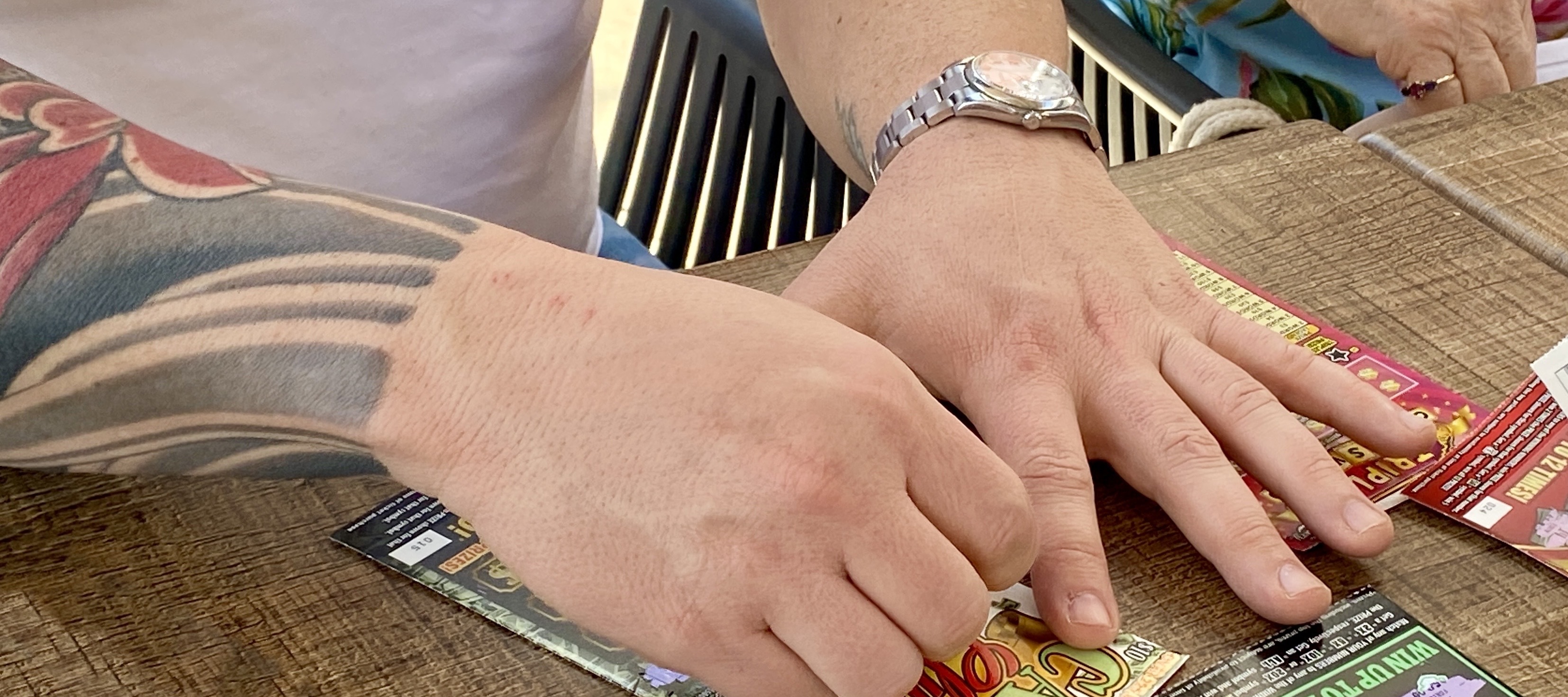 Close up of people scratching lottery tickets