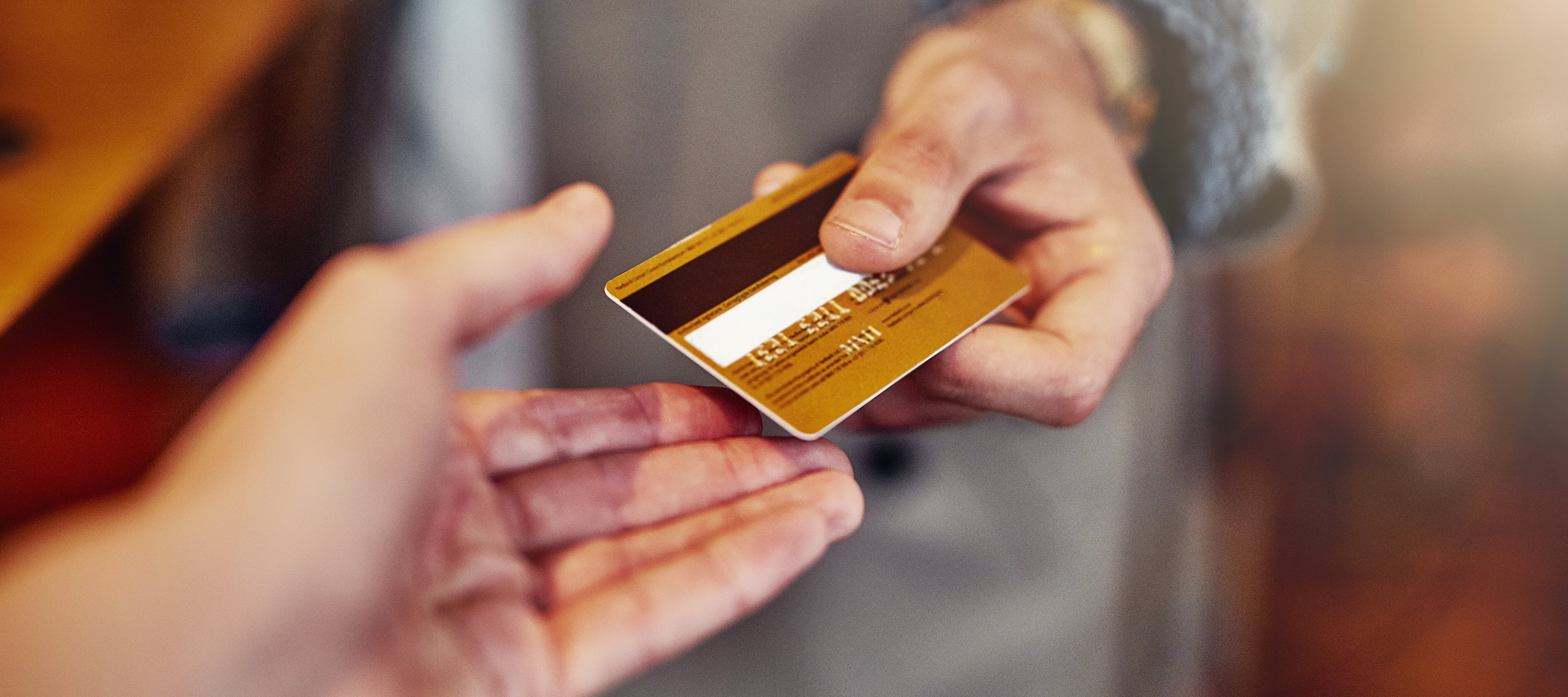 Person handing over gold credit card for transaction