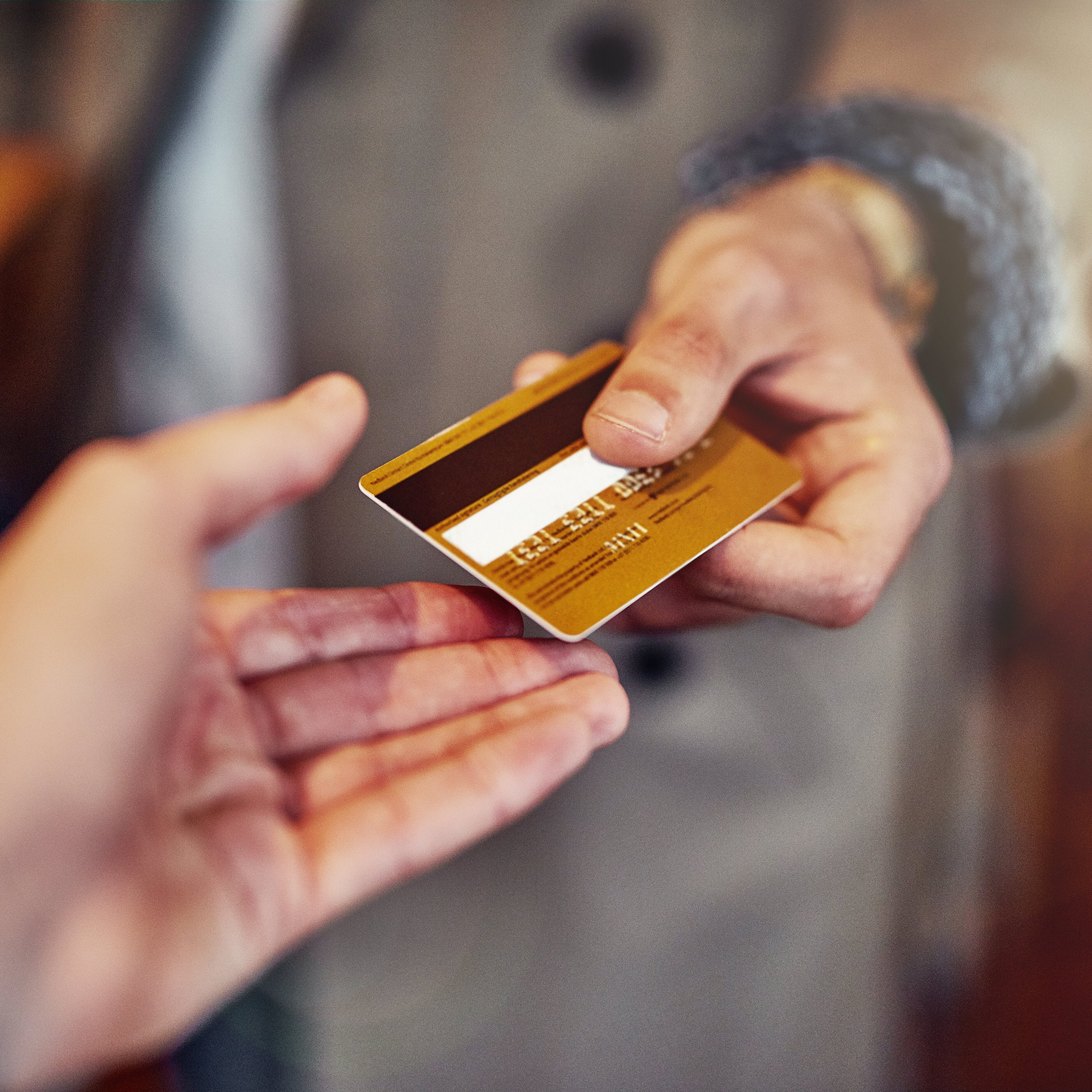Person handing over gold credit card for transaction